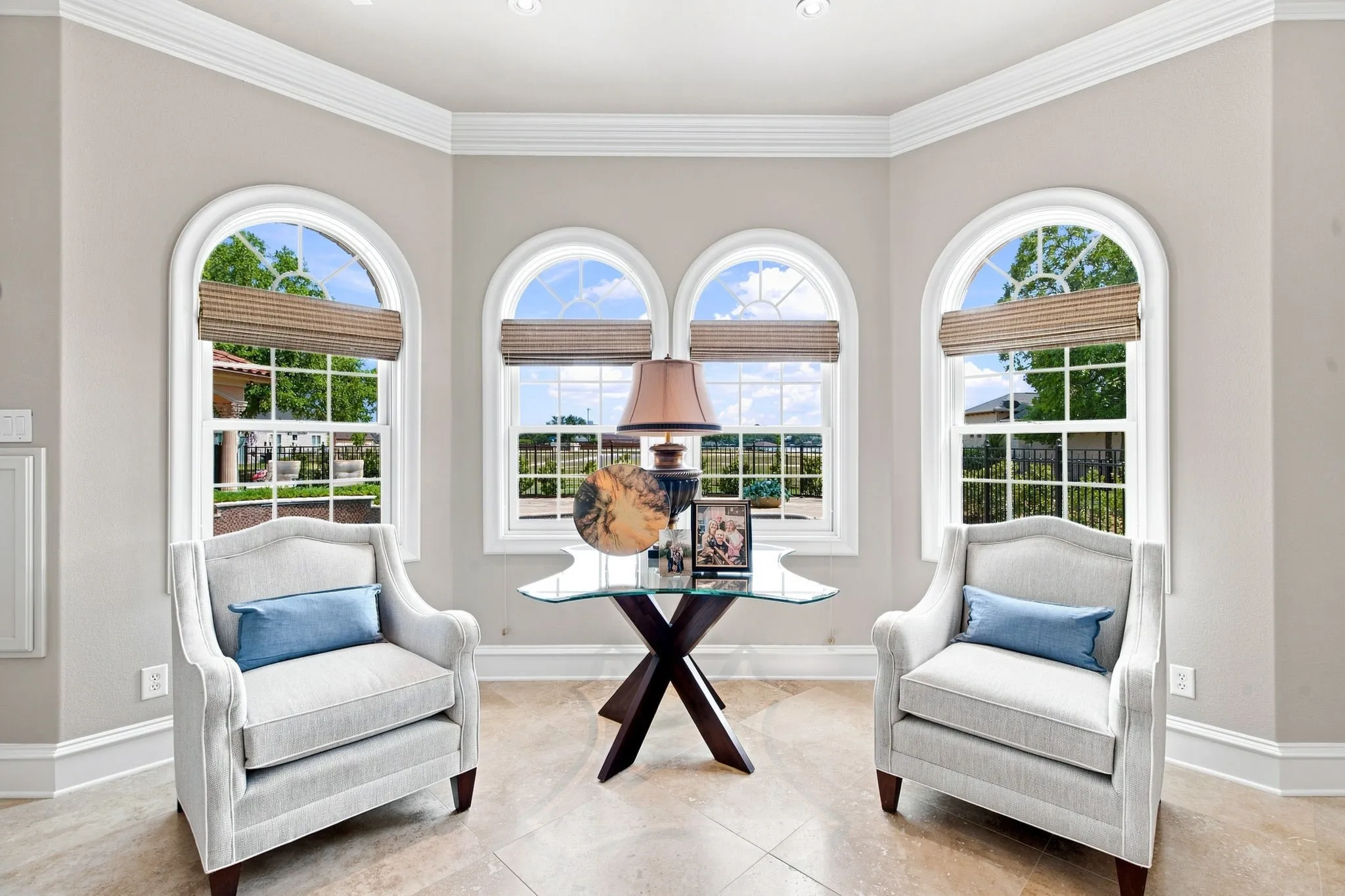 Arched windows with grid panes, crown molding, and recessed lighting