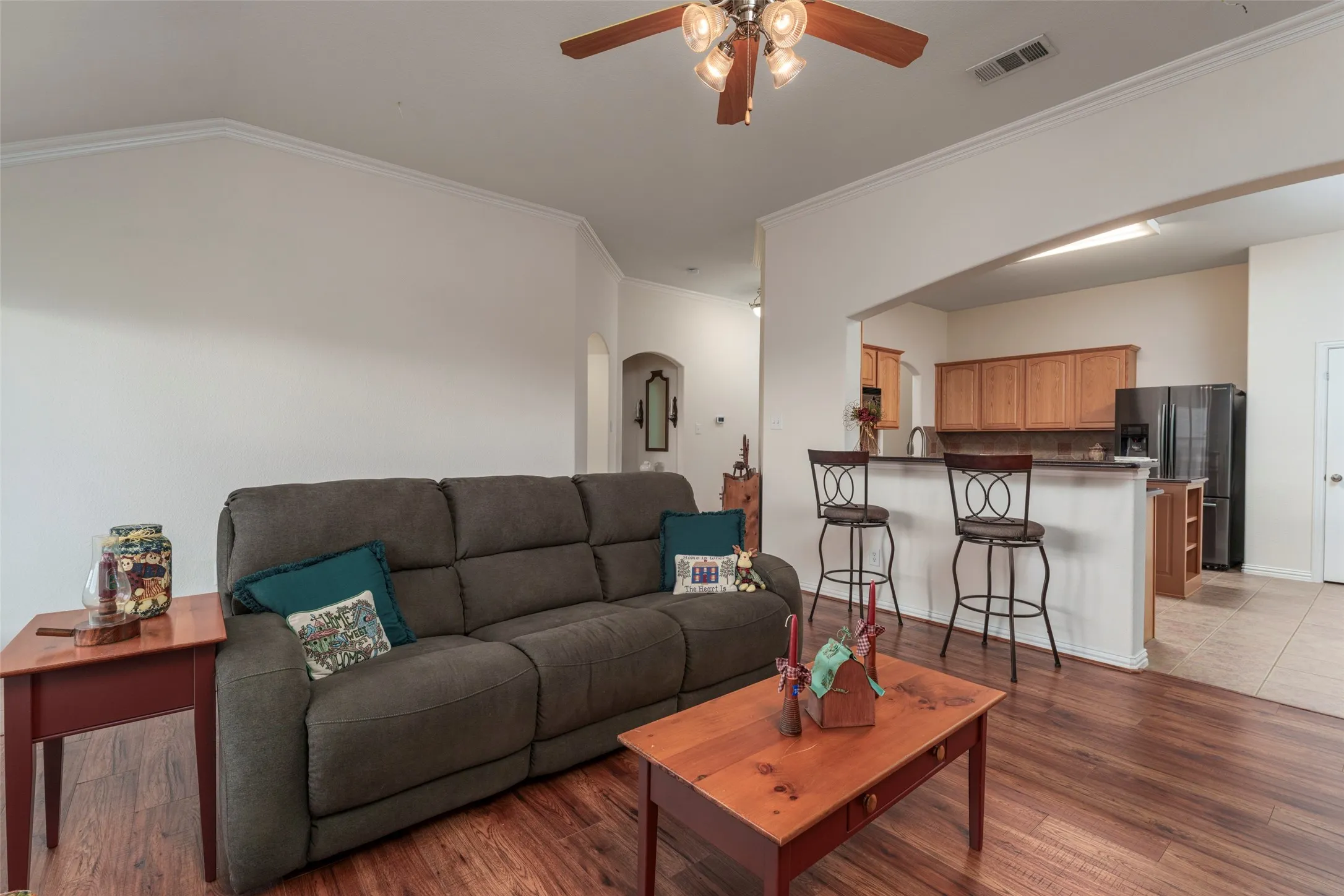 Spacious living area featuring wood-finish flooring and crown molding