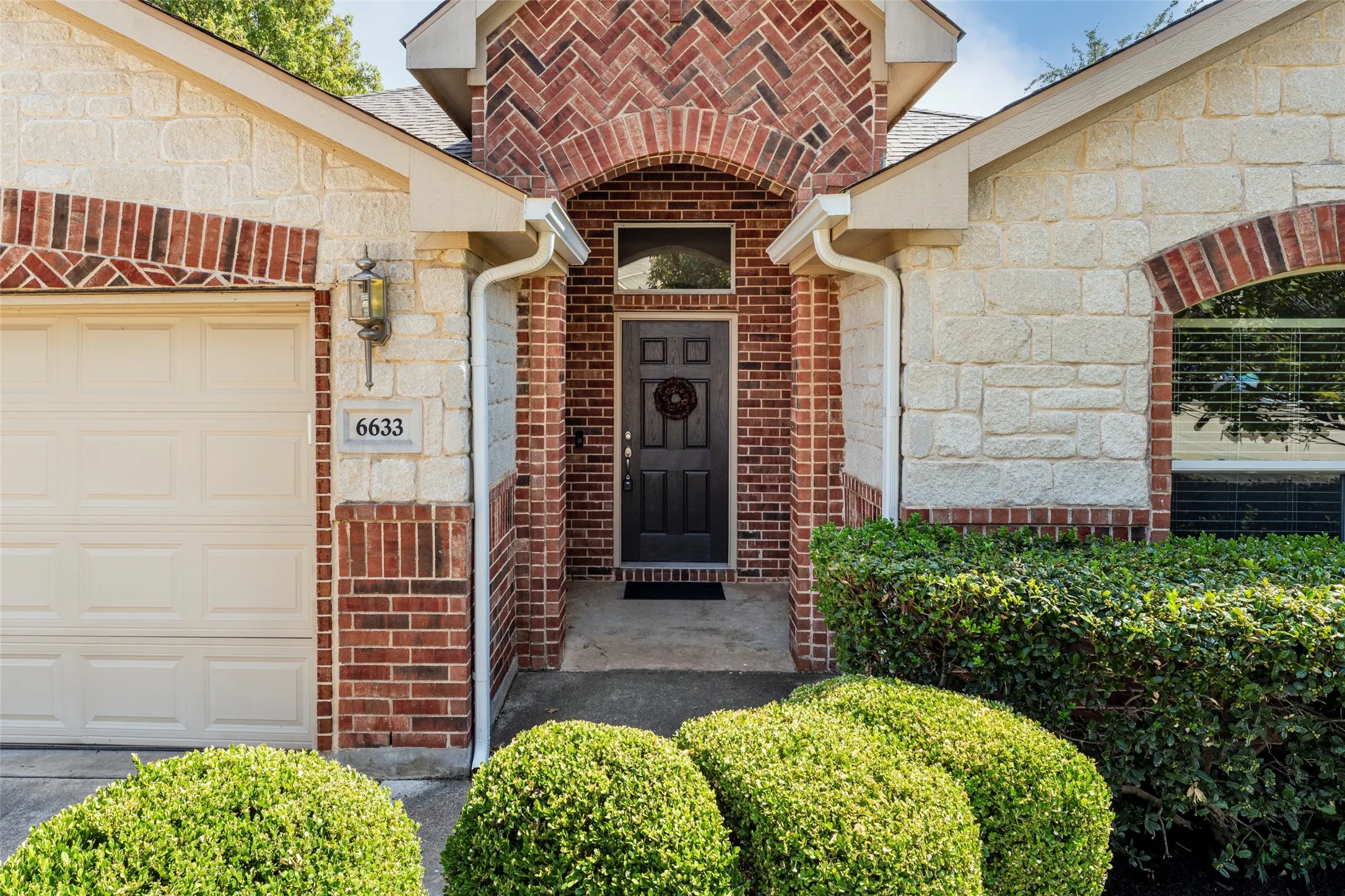 Brick and stone exterior with an arched entryway