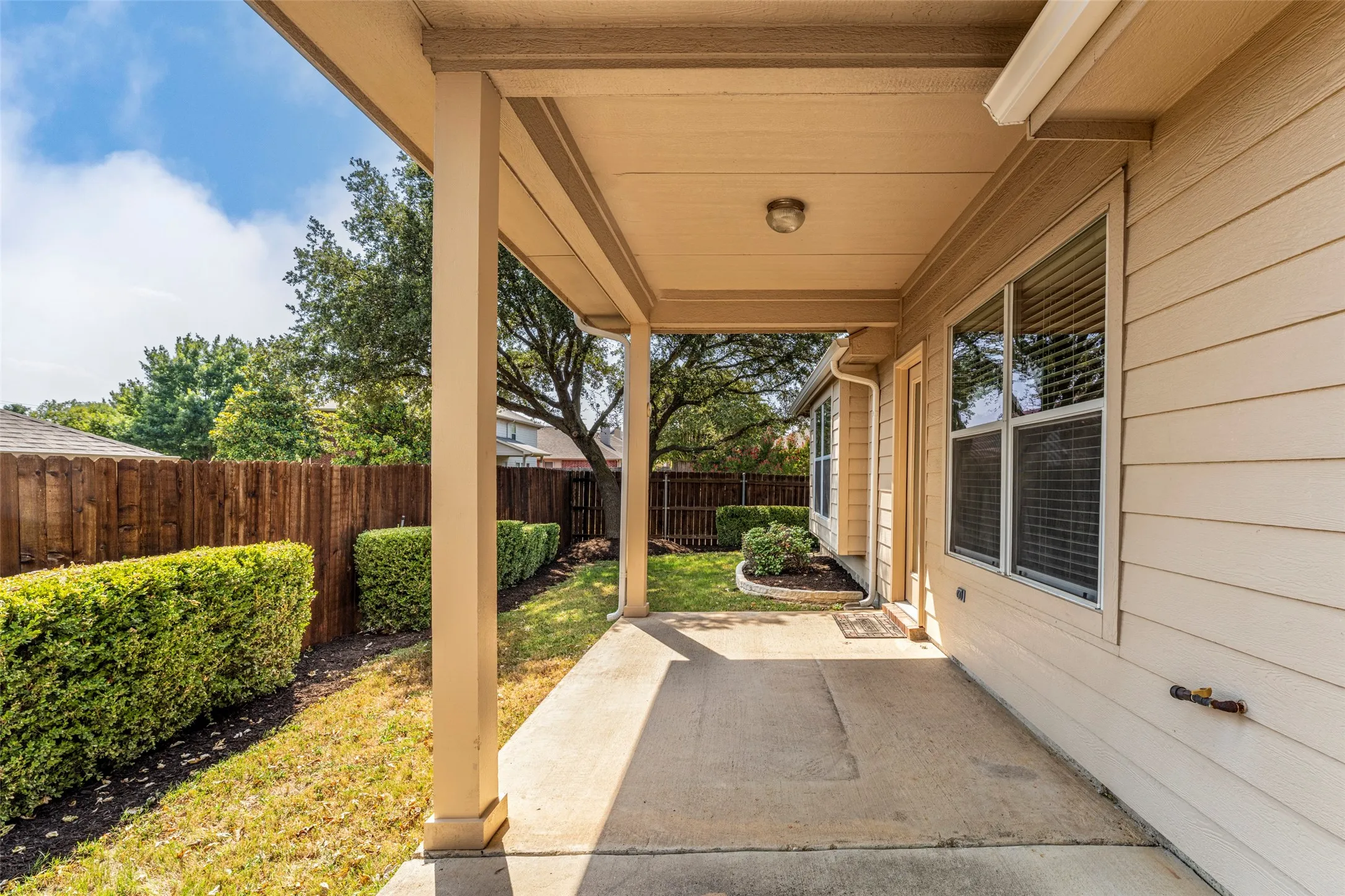 Covered patio featuring a concrete surface, siding exterior, and a privacy fence