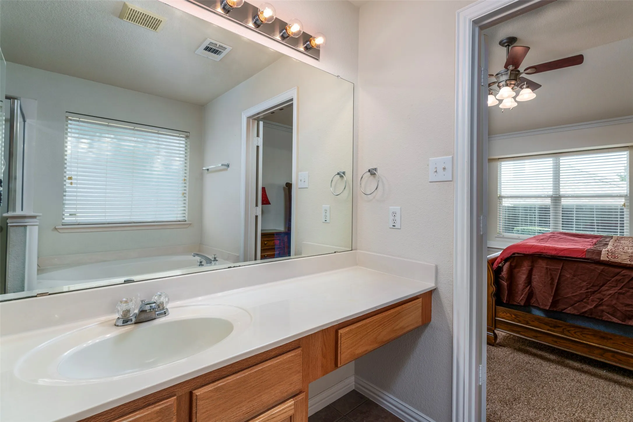 Built-in vanity with a single basin, laminate countertop, and wood-finish cabinetry