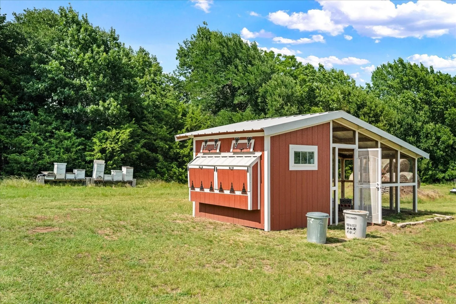 Red outbuilding featuring a white metal roof and a screened-in enclosure