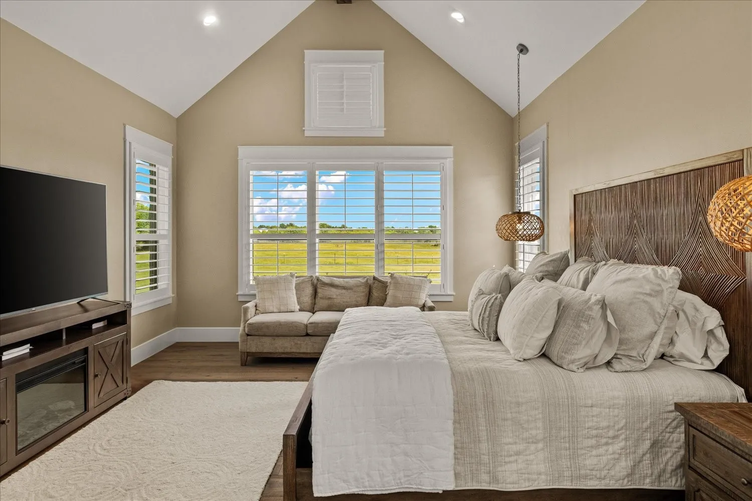 Vaulted ceiling with recessed lighting, wood-finish flooring, white window shutters, transom window, and a built-in media console