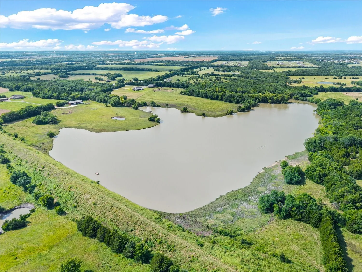 Expansive private lake with natural shoreline and surrounding wooded areas