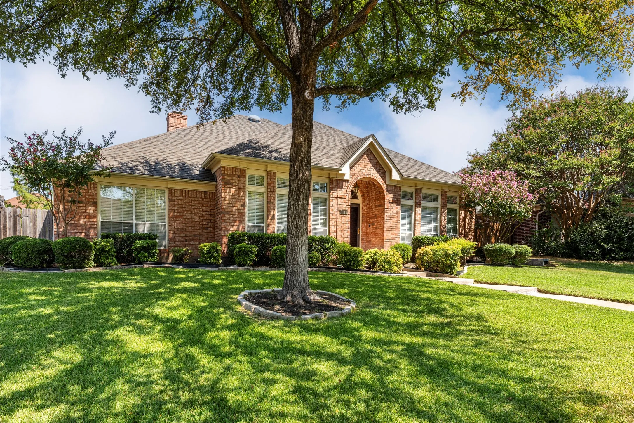 Brick exterior with an arched entryway and covered front porch