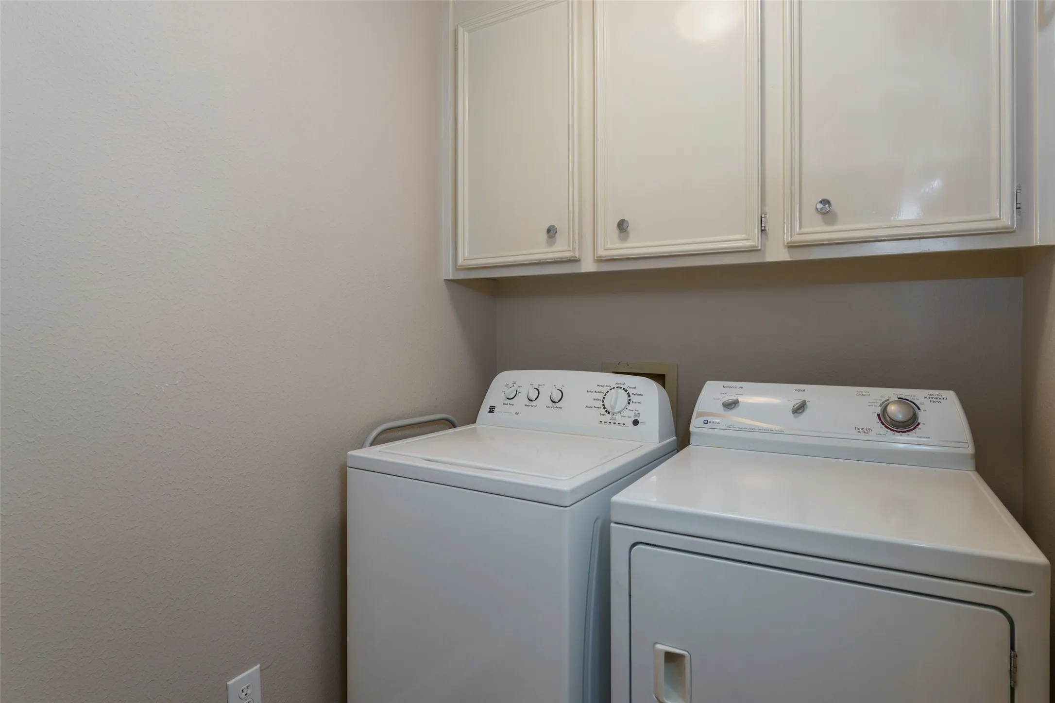 Built-in cabinetry with silver-toned hardware and light-toned walls