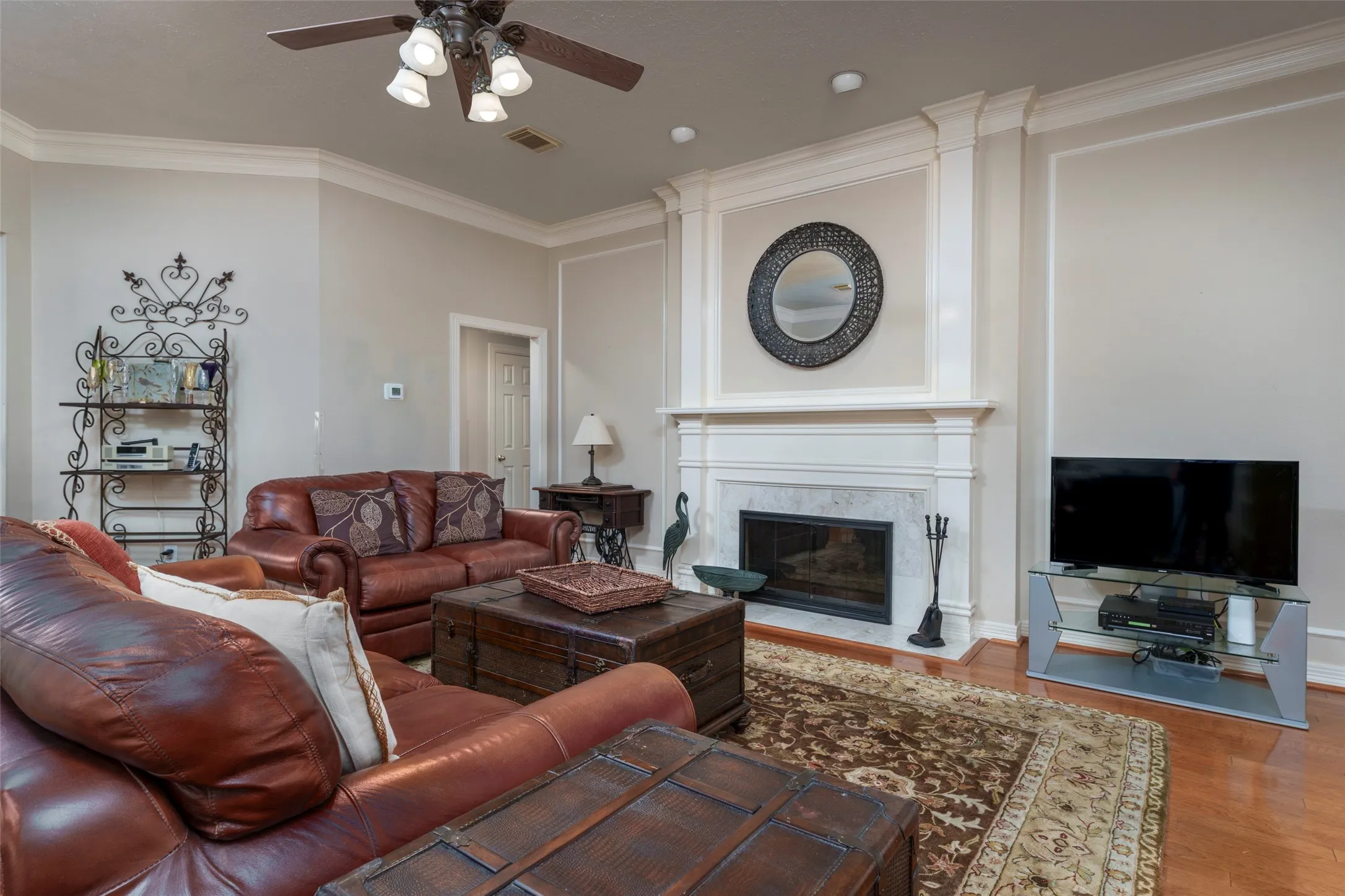 Living area featuring a fireplace with a stone surround, wood mantel, and detailed millwork