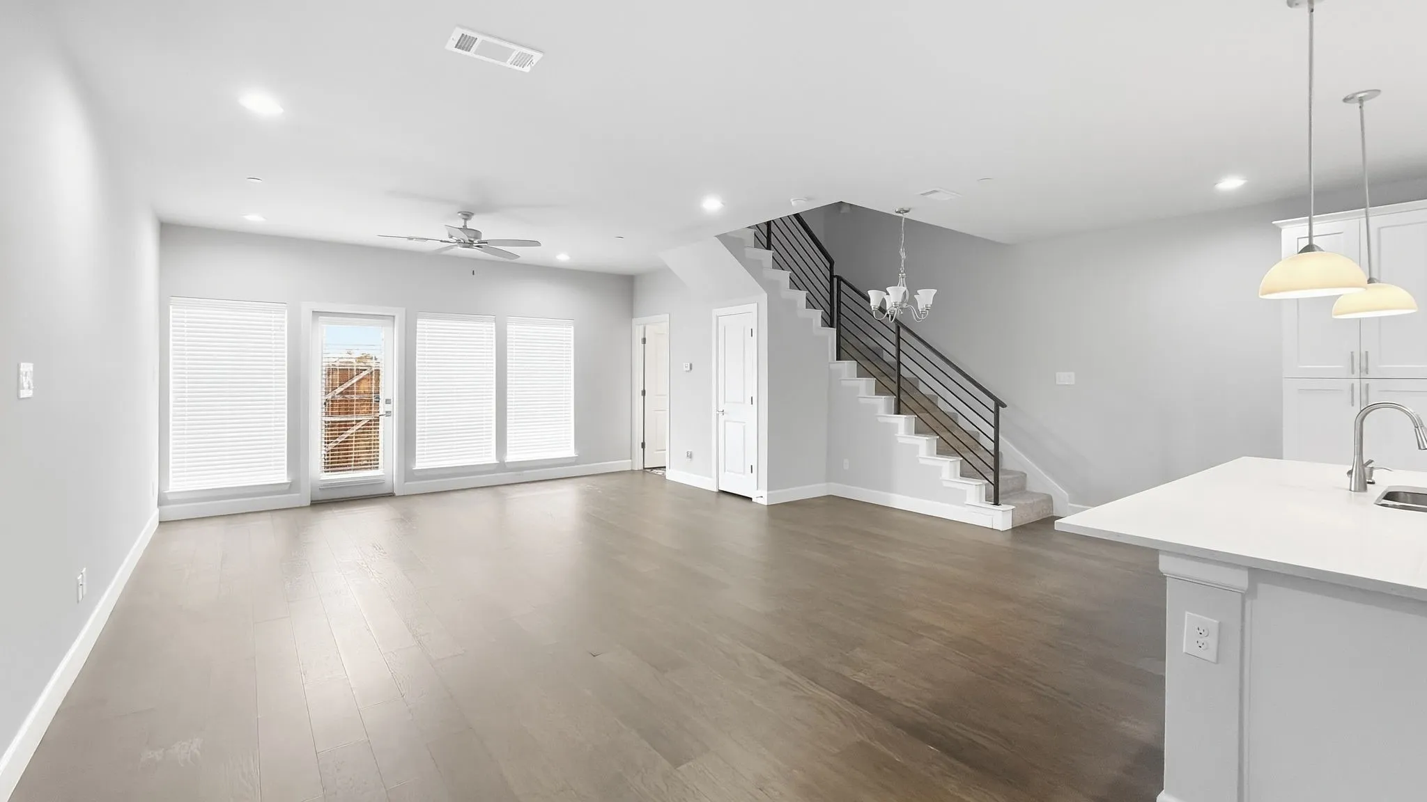 Open-concept living space featuring wood-finish flooring, recessed lighting, and a contemporary ceiling fan