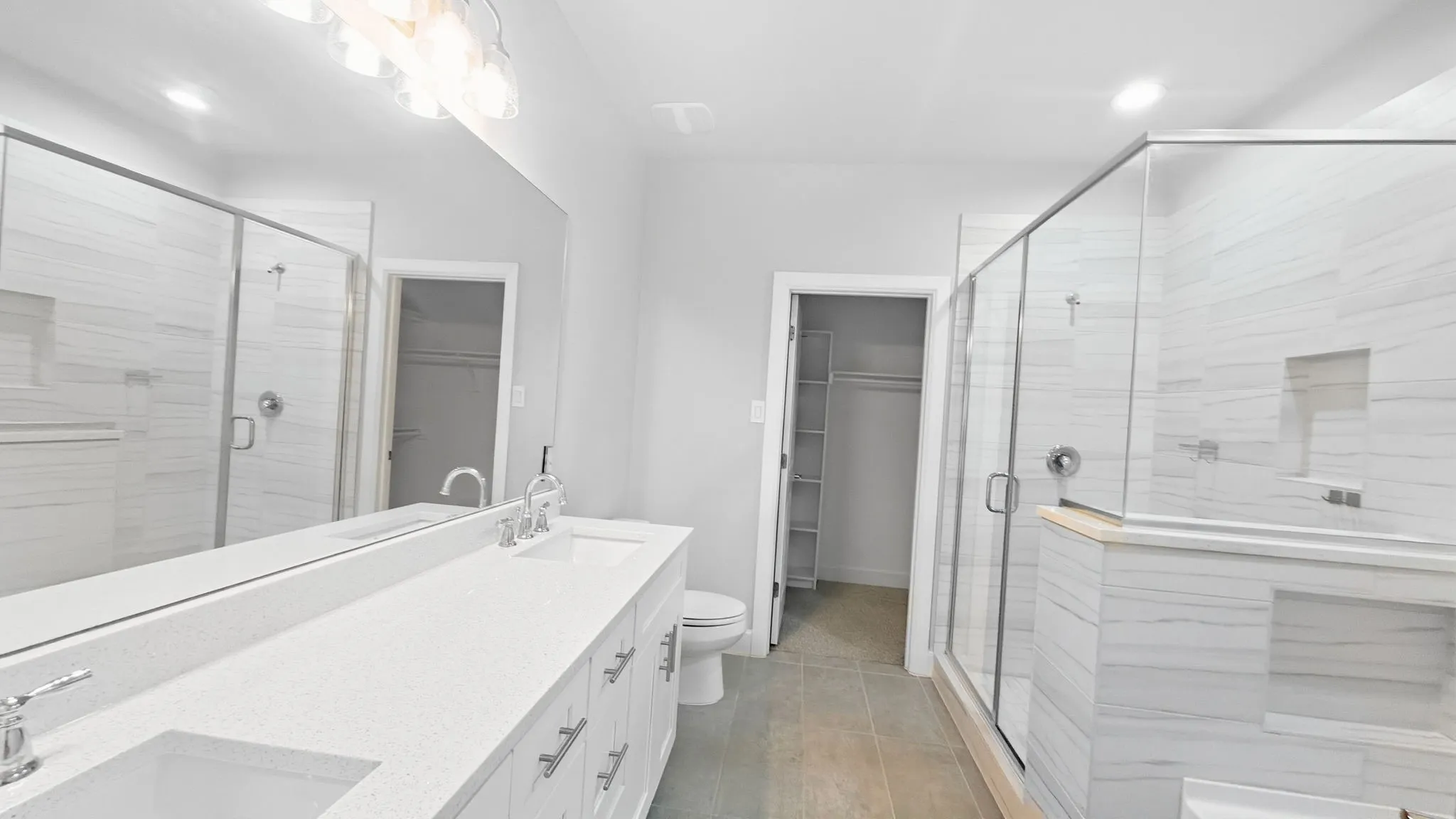 Double vanity with white cabinetry, quartz countertop, and undermount sinks