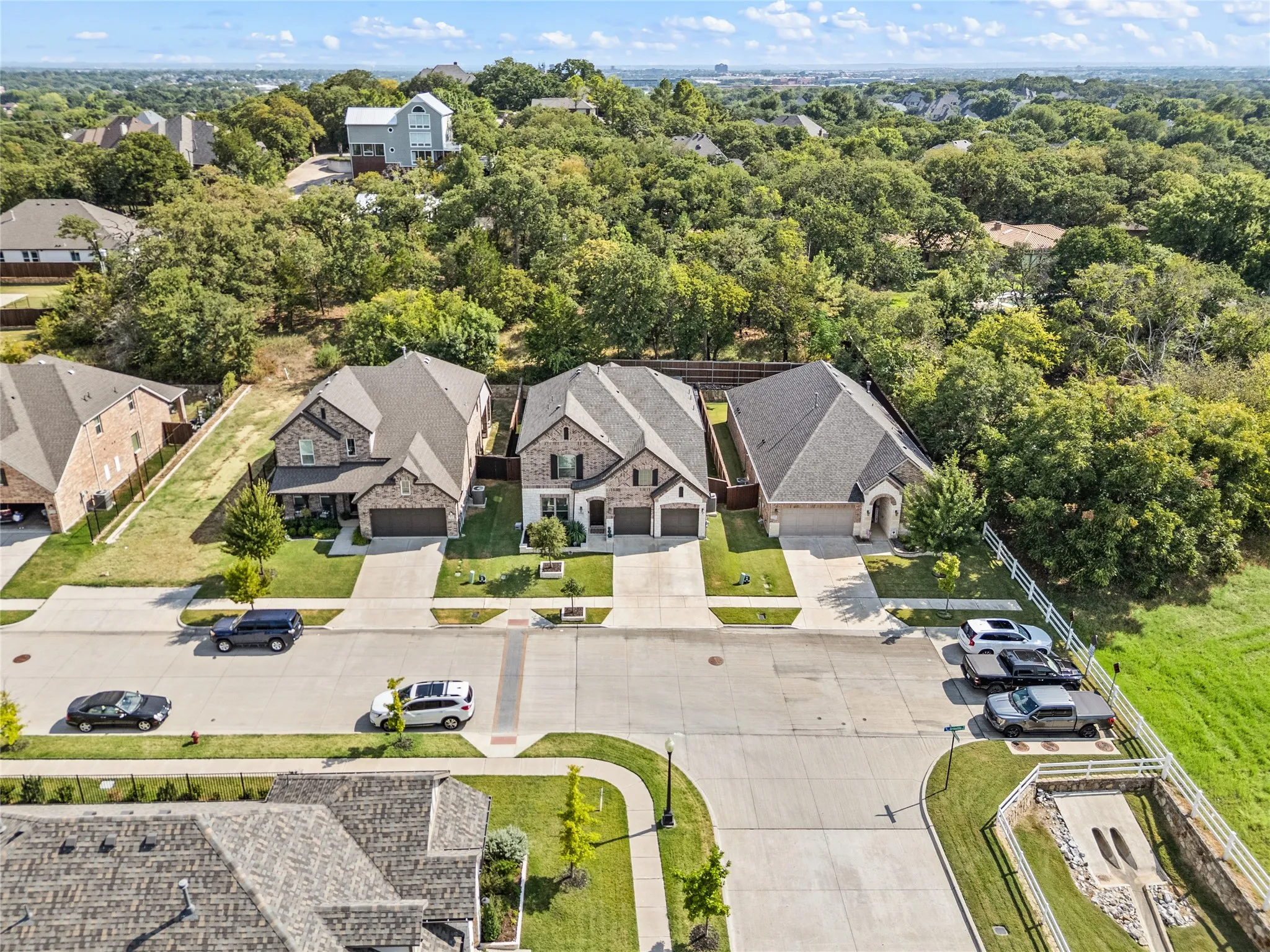 Stone and brick exterior with a dark shingle roof, two-car garage, and a concrete driveway