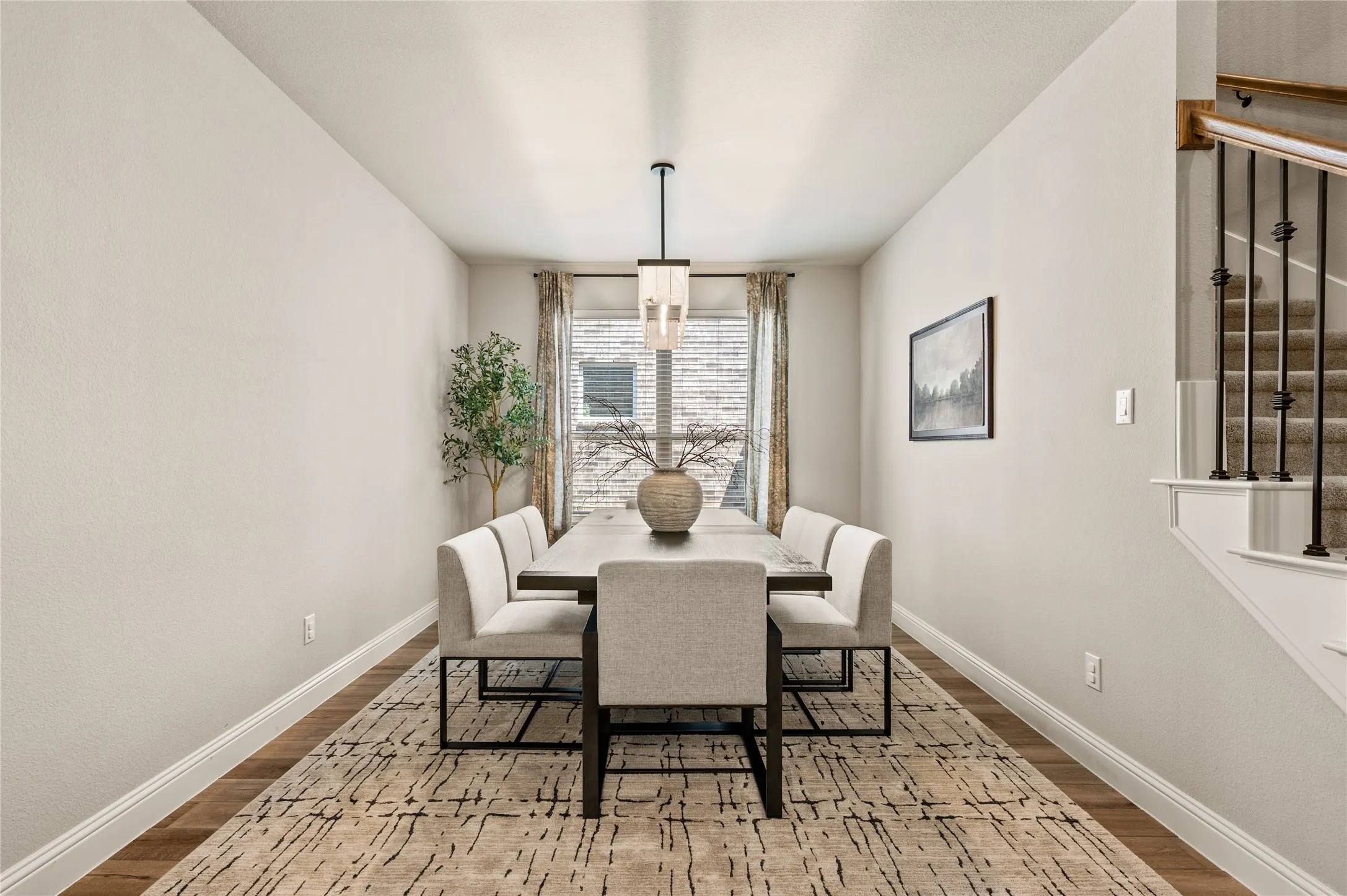 Recessed lighting, wood-finish flooring, staircase with wrought iron balusters, and a modern rectangular chandelier