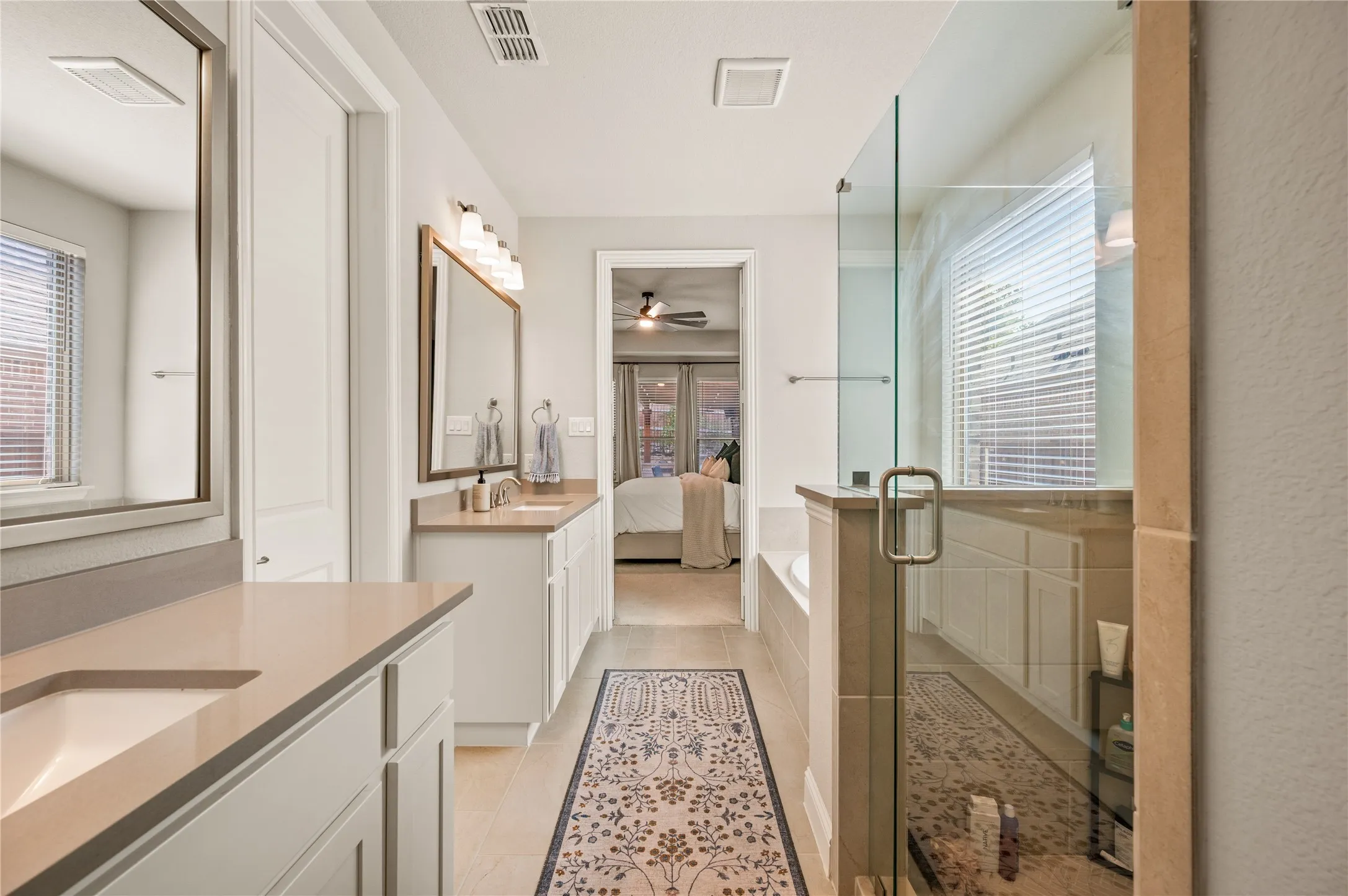 Dual vanity with under-mount sinks, light-toned countertops, and framed mirrors