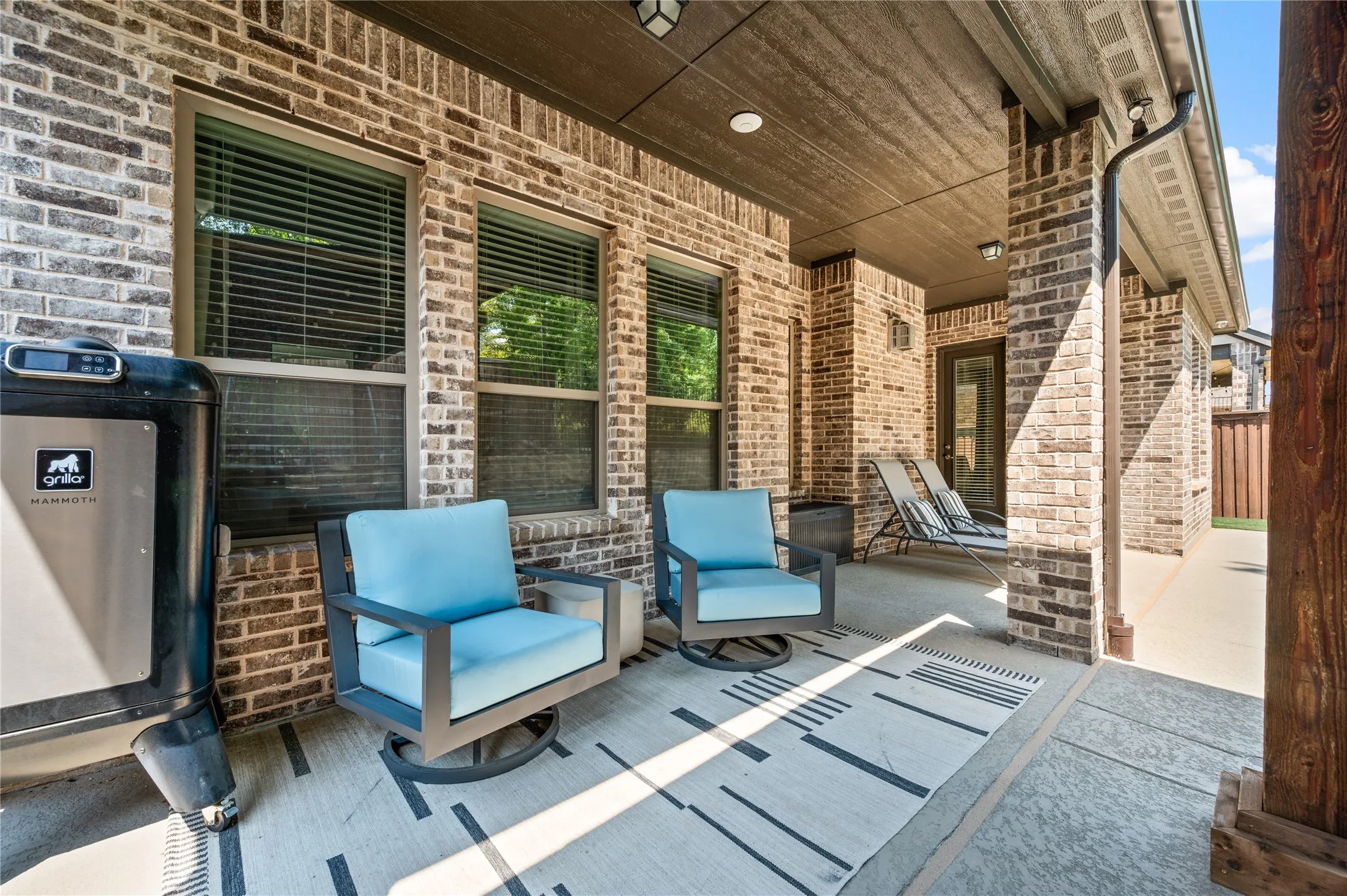 Covered patio with brick siding, a wood-finish ceiling, and recessed lighting
