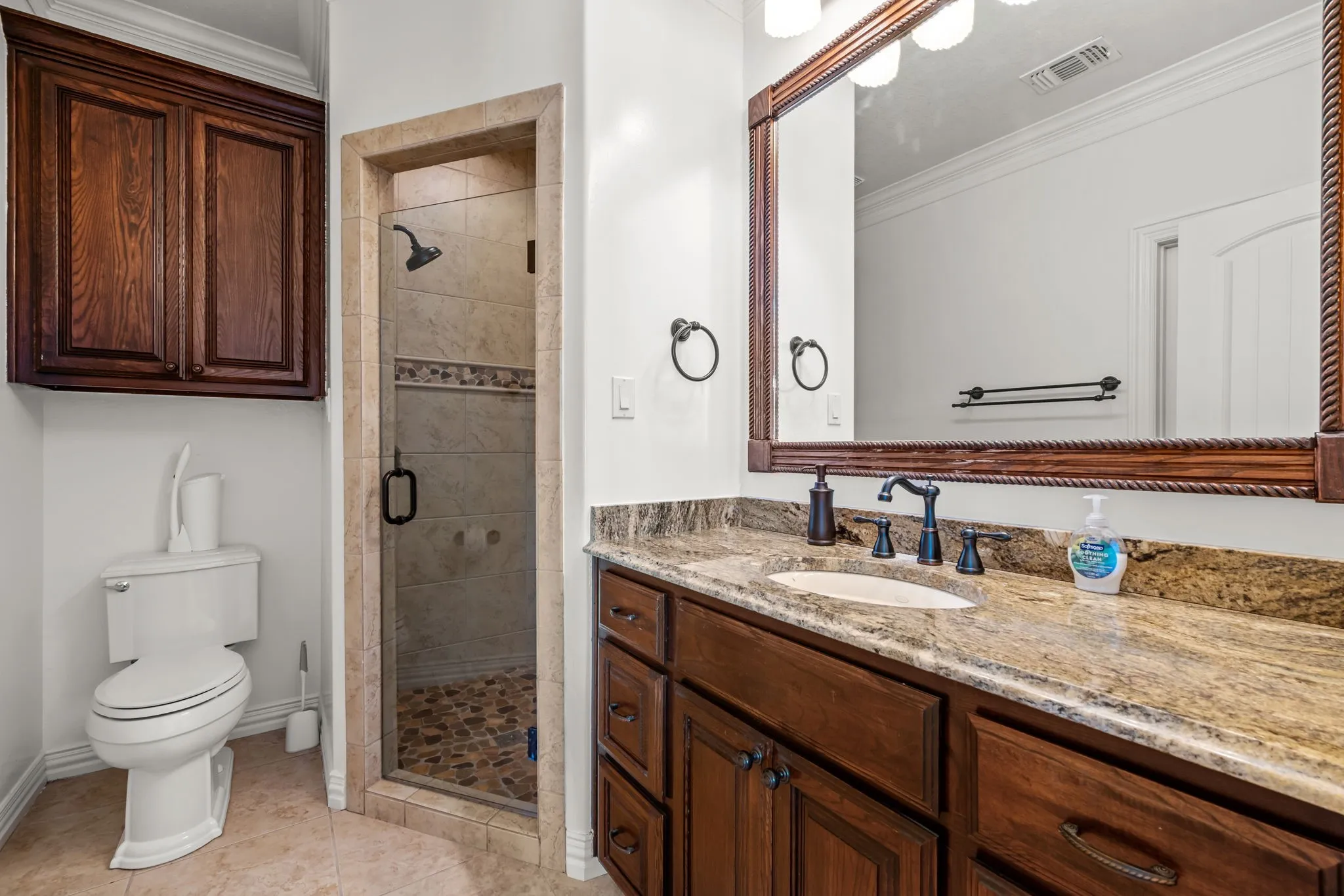 Wood-finish vanity with an integrated sink and stone countertop