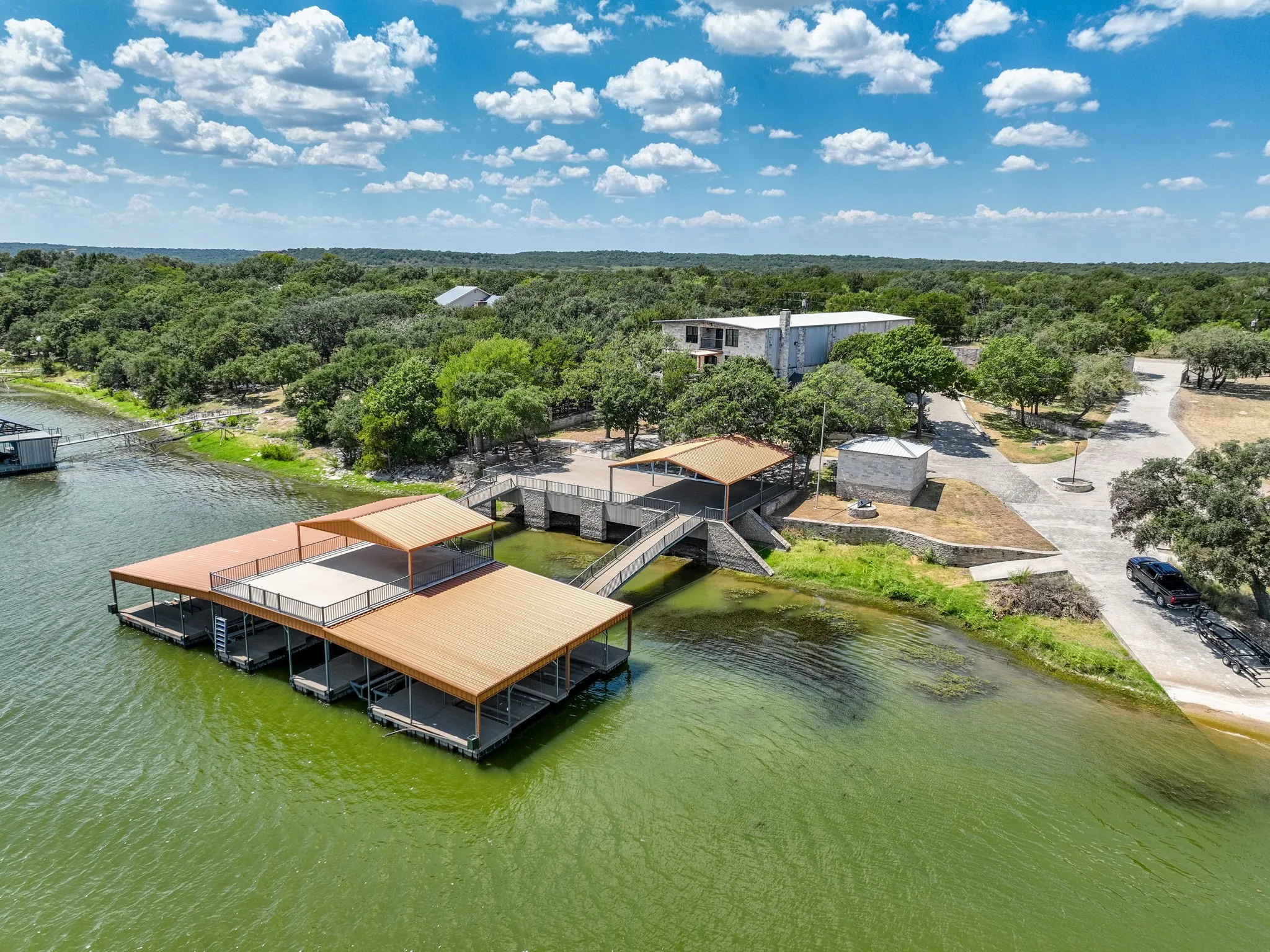 Multi-slip covered boat dock with an upper deck, private boat ramp, and expansive waterfront