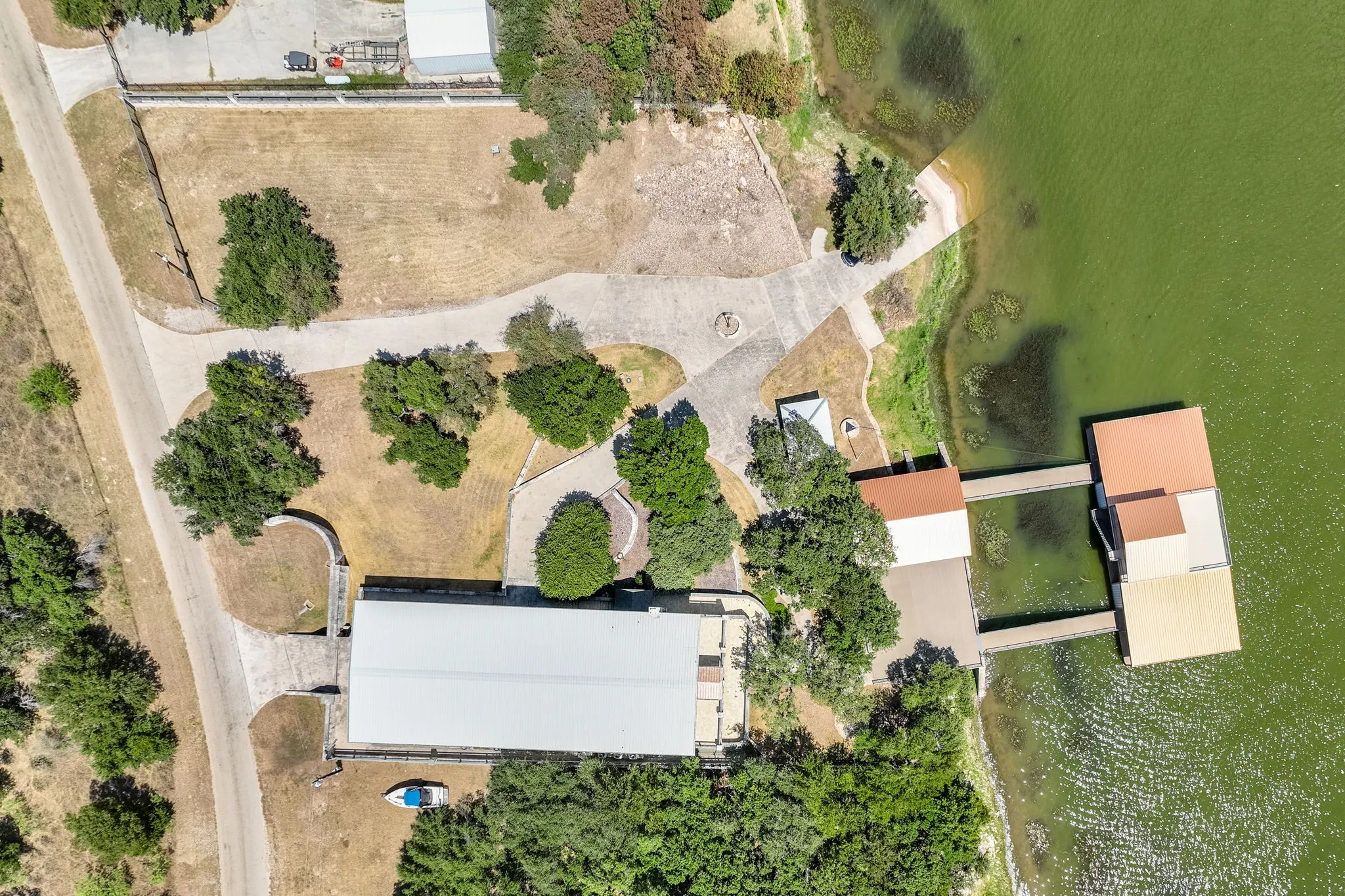 Waterfront property featuring extensive dock structures, a sheltered boat slip, and a concrete shoreline path
