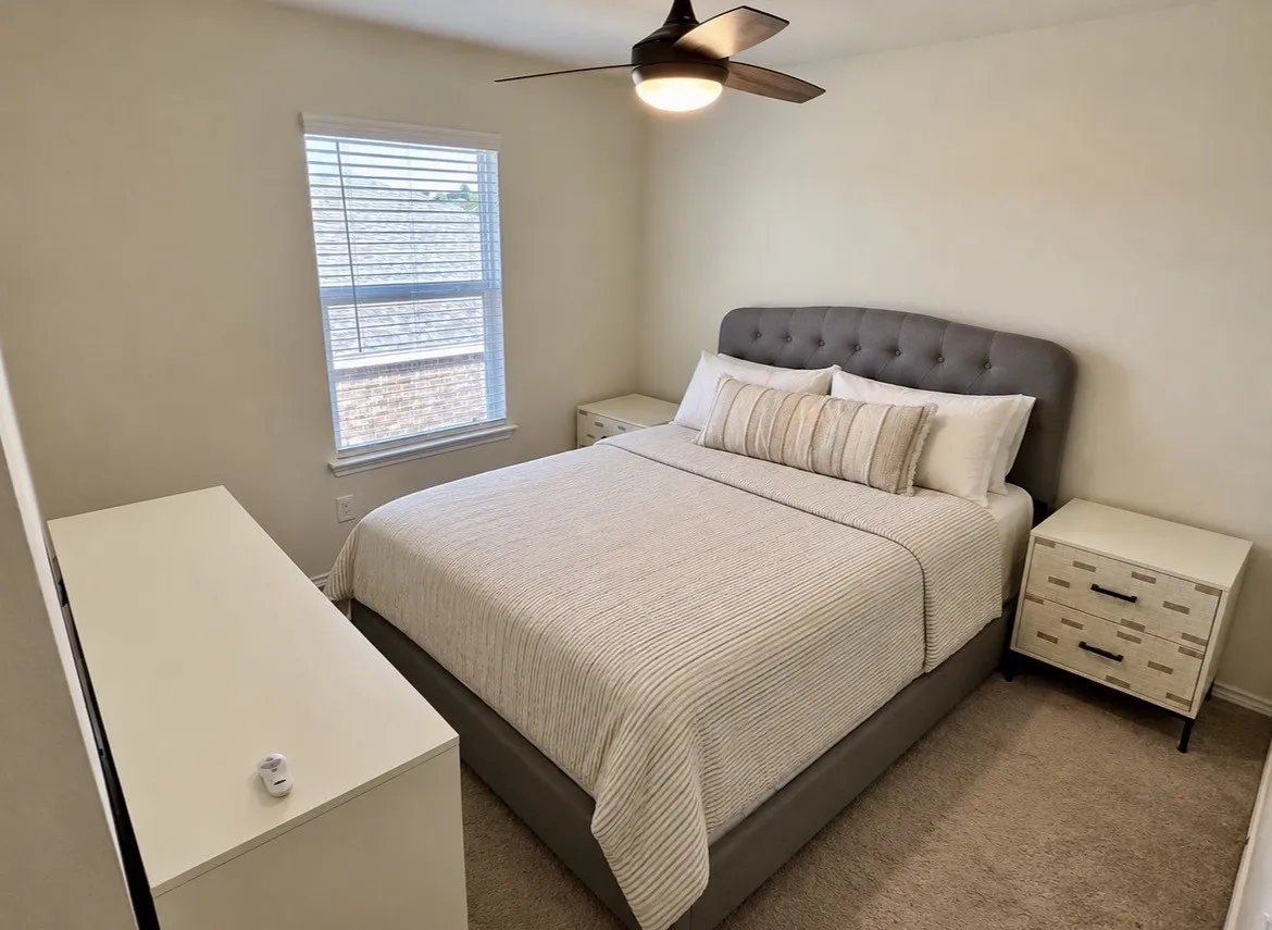 Window with blinds, wood-finish ceiling fan, and carpeted flooring