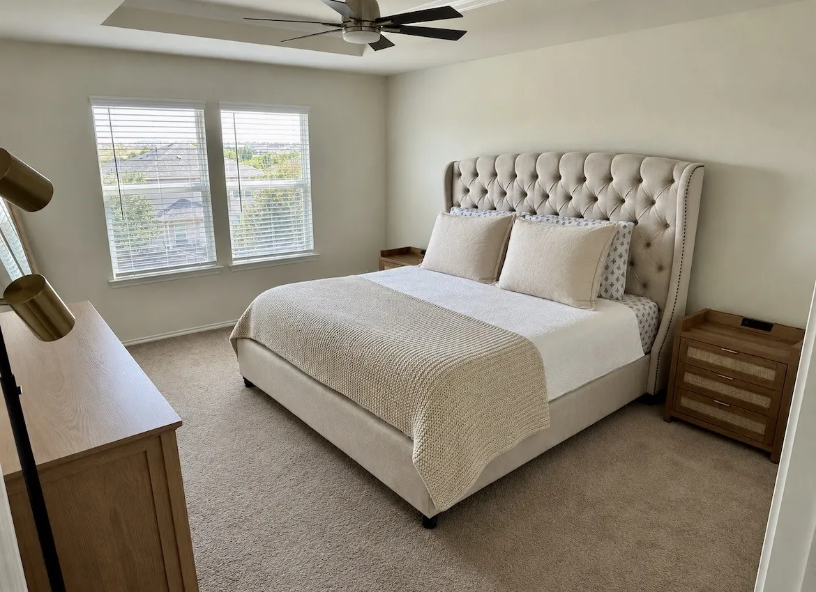 Tray ceiling with a ceiling fan, dual windows with blinds, and carpeted flooring