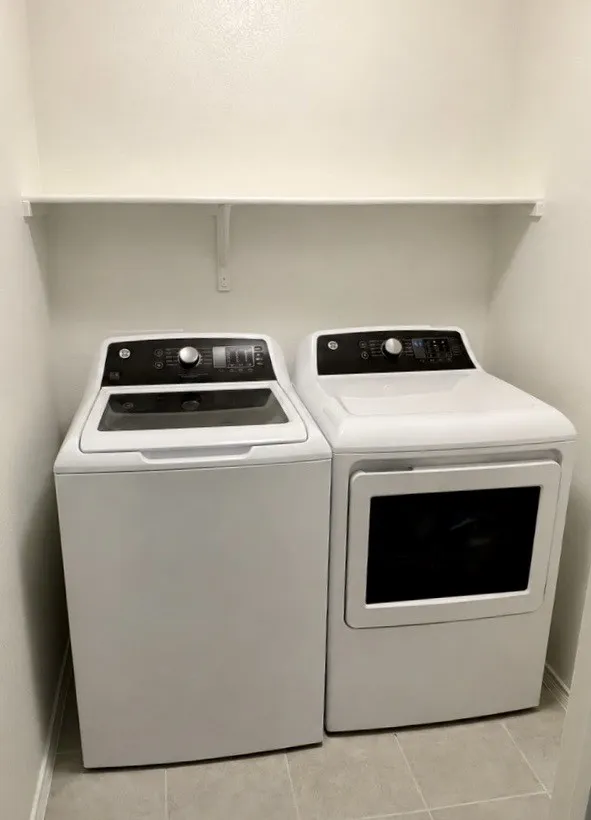 Upstairs Laundry with tile flooring and an overhead storage shelf