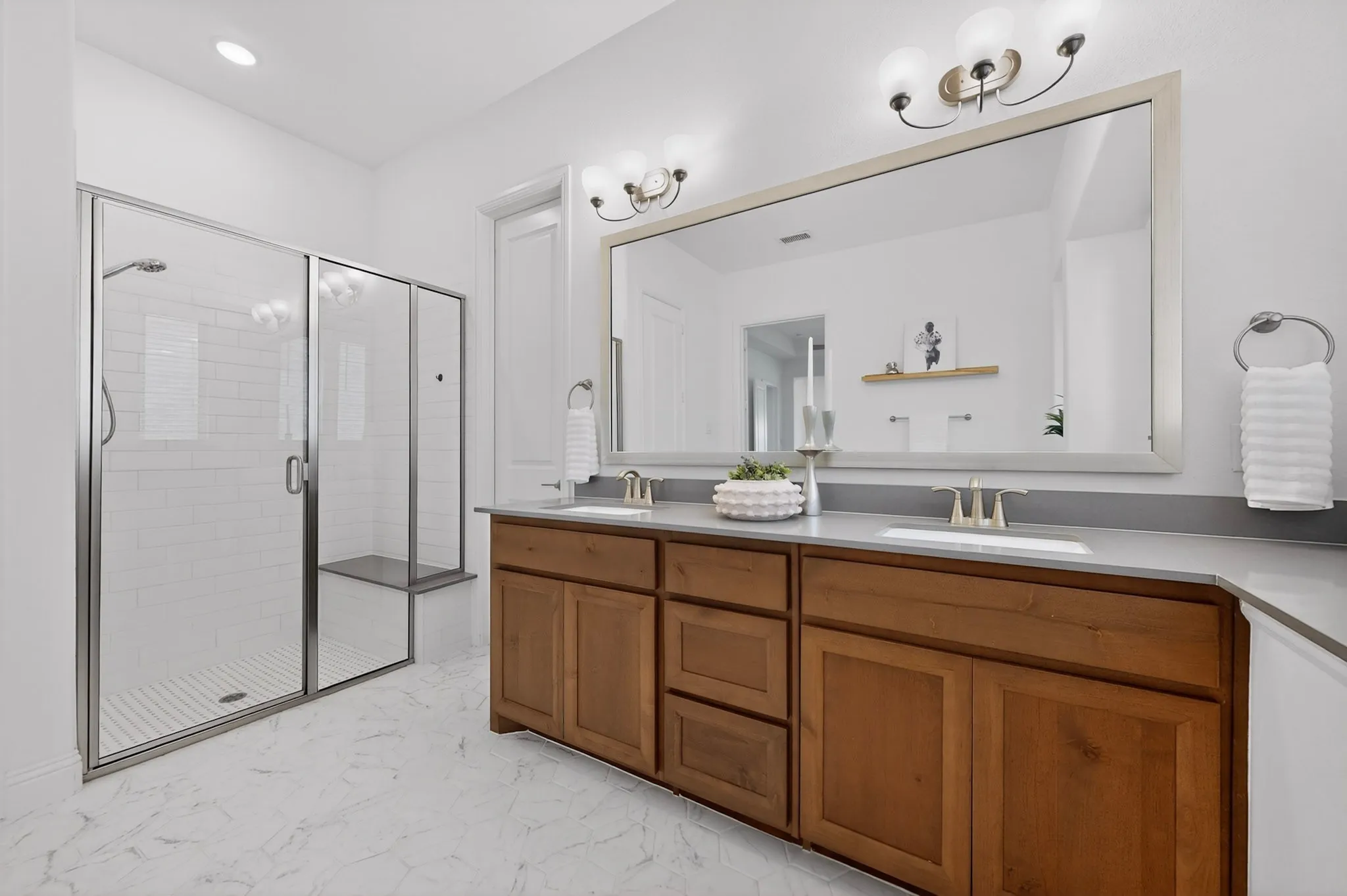 Dual wood-finish vanity with integrated sinks and light-toned countertops