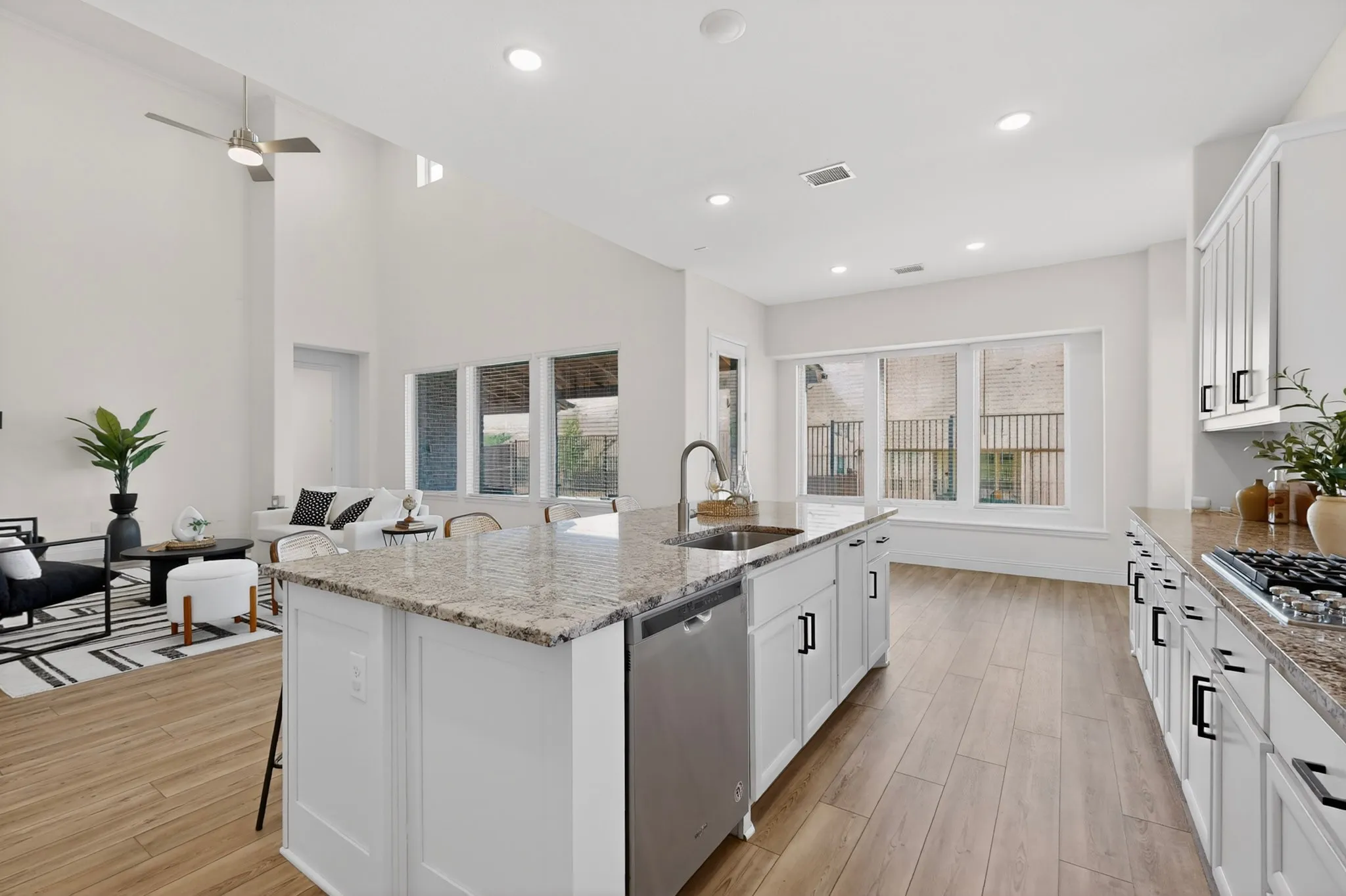 Kitchen island with stone countertop, stainless steel sink, and integrated dishwasher