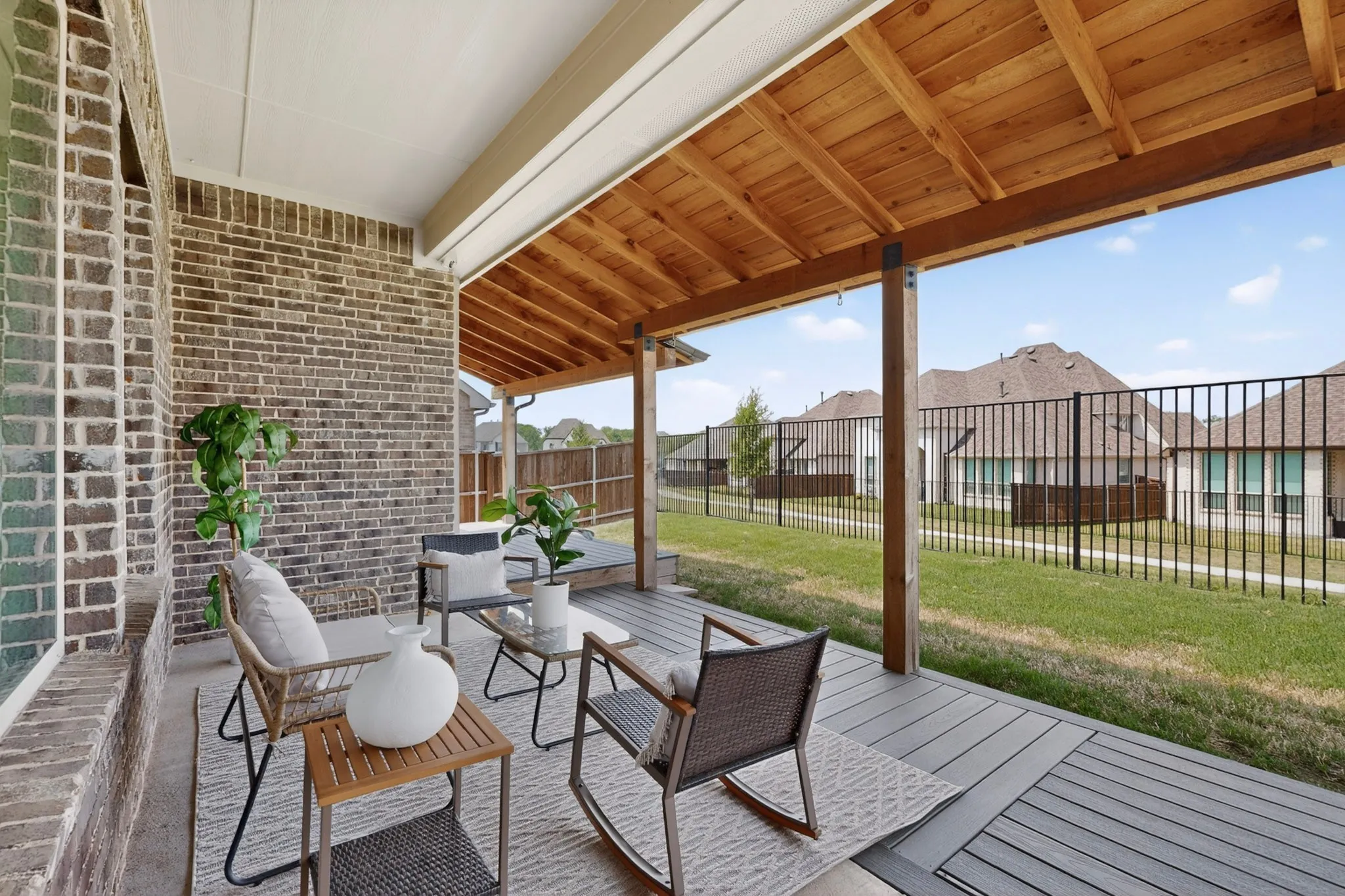 Covered patio featuring a wood-plank ceiling, exposed wood beams, and a composite deck