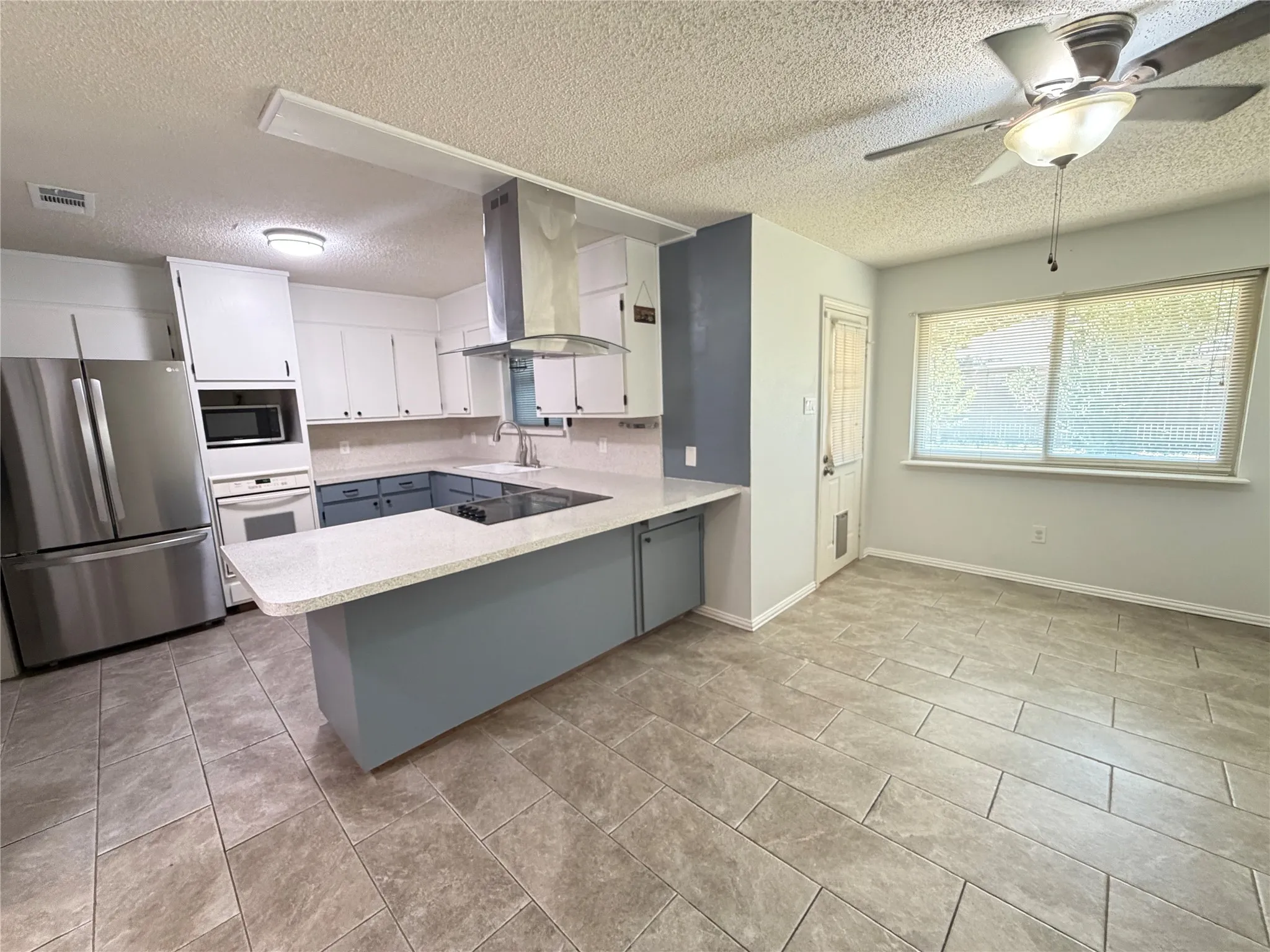 Modern kitchen featuring stainless steel appliances, a range hood, and a built-in oven and microwave
