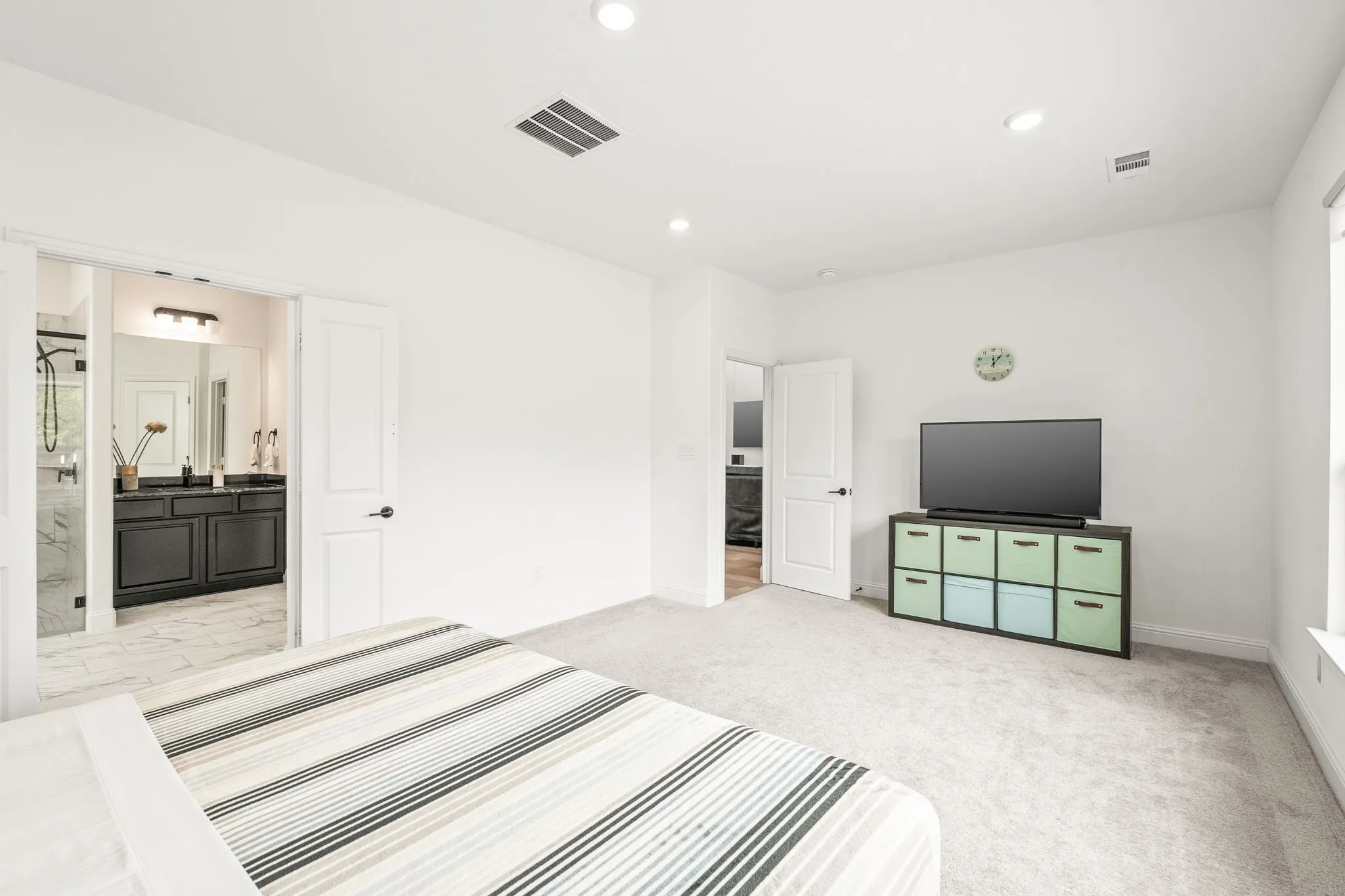 Unfurnished bedroom featuring light carpet, recessed lighting, and ensuite bath