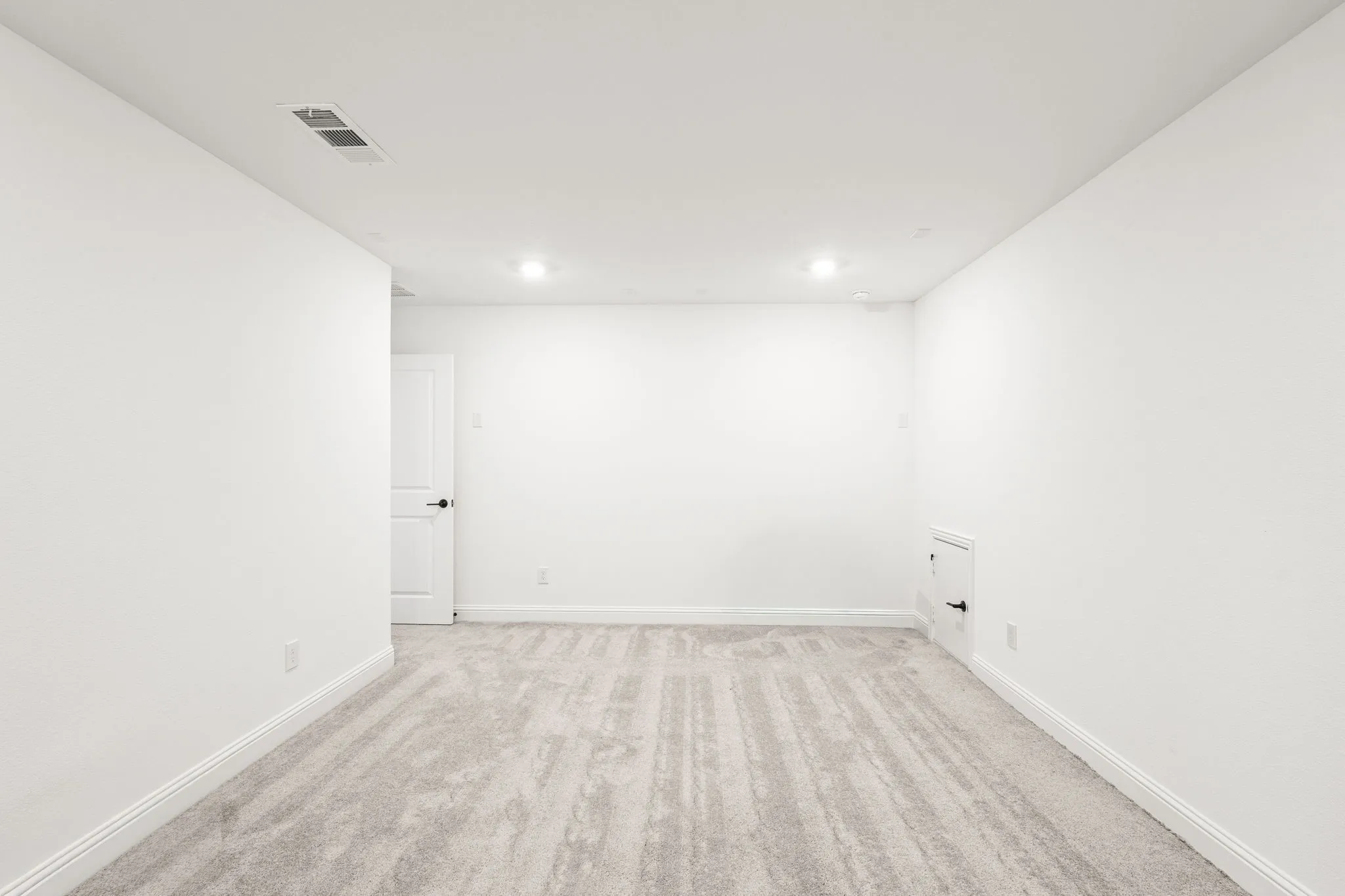 Spare room with light carpet and baseboards