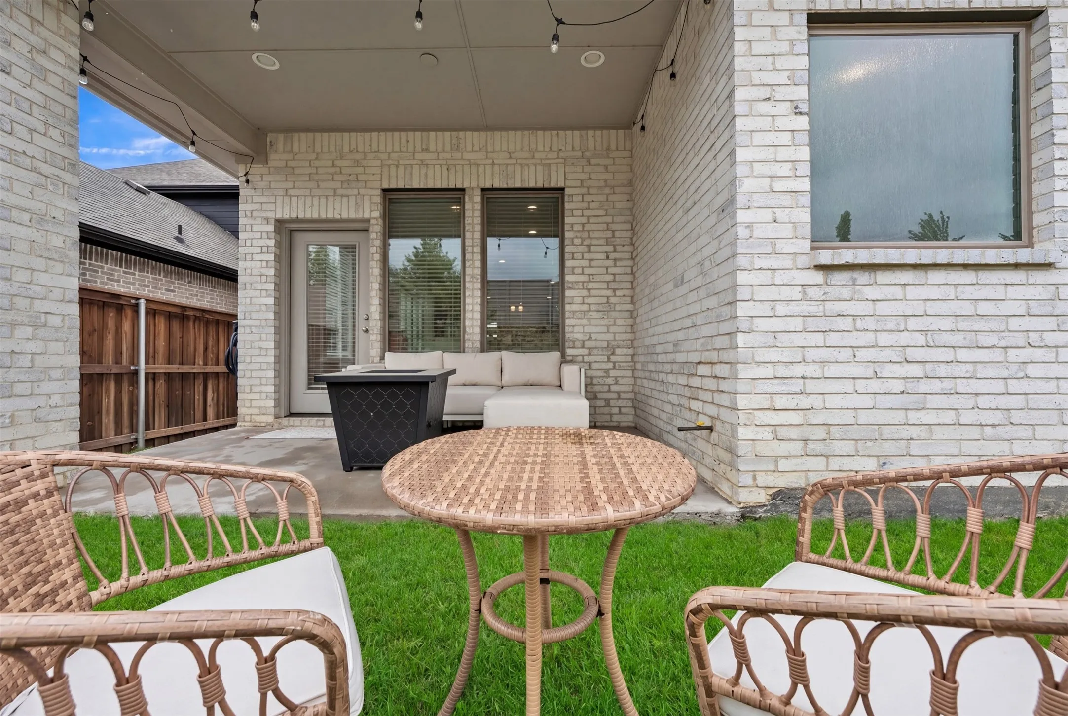 Covered patio featuring a concrete surface, overhead string lighting, and direct outdoor access