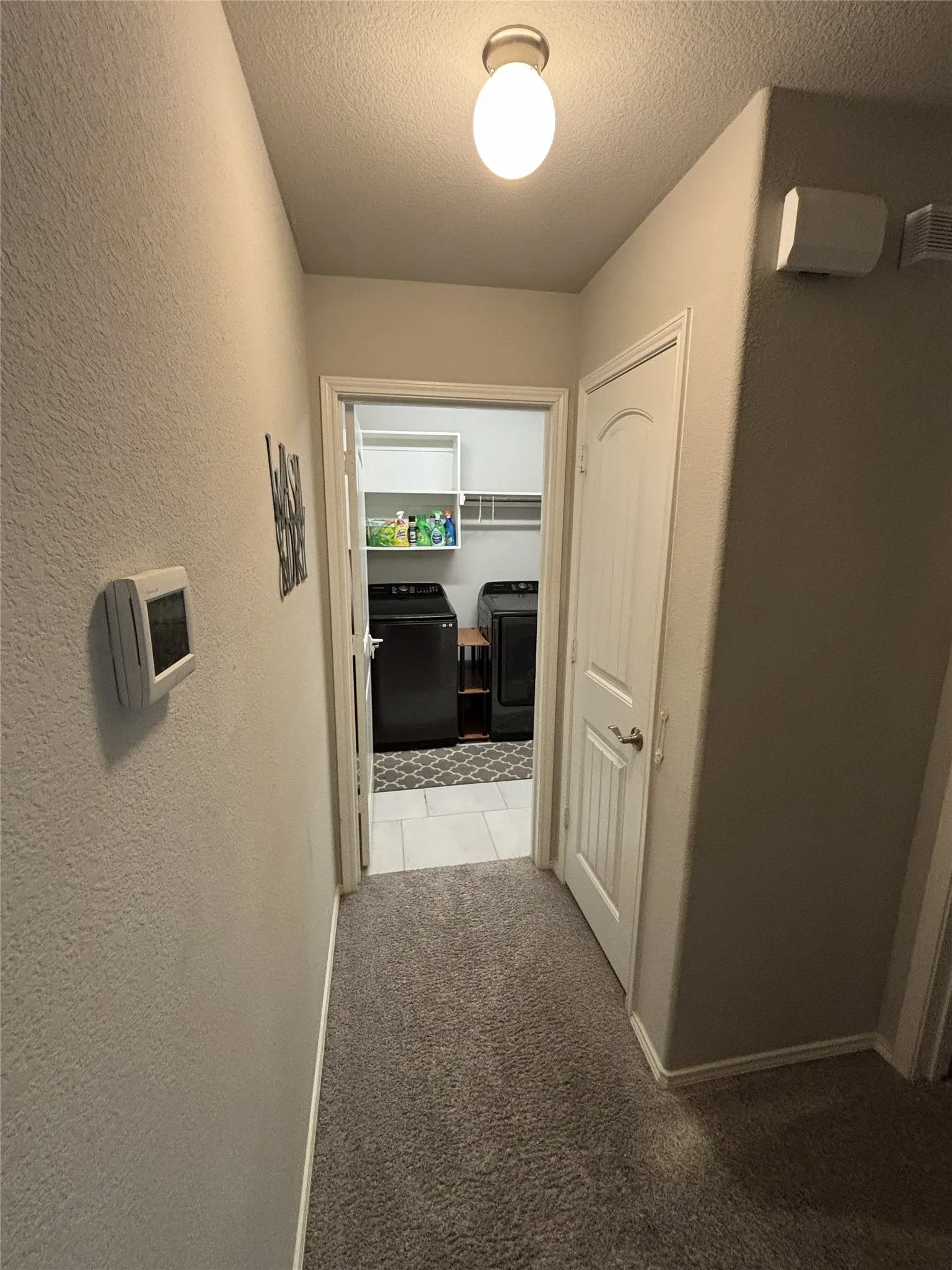 Laundry area featuring white shelving and a tiled floor