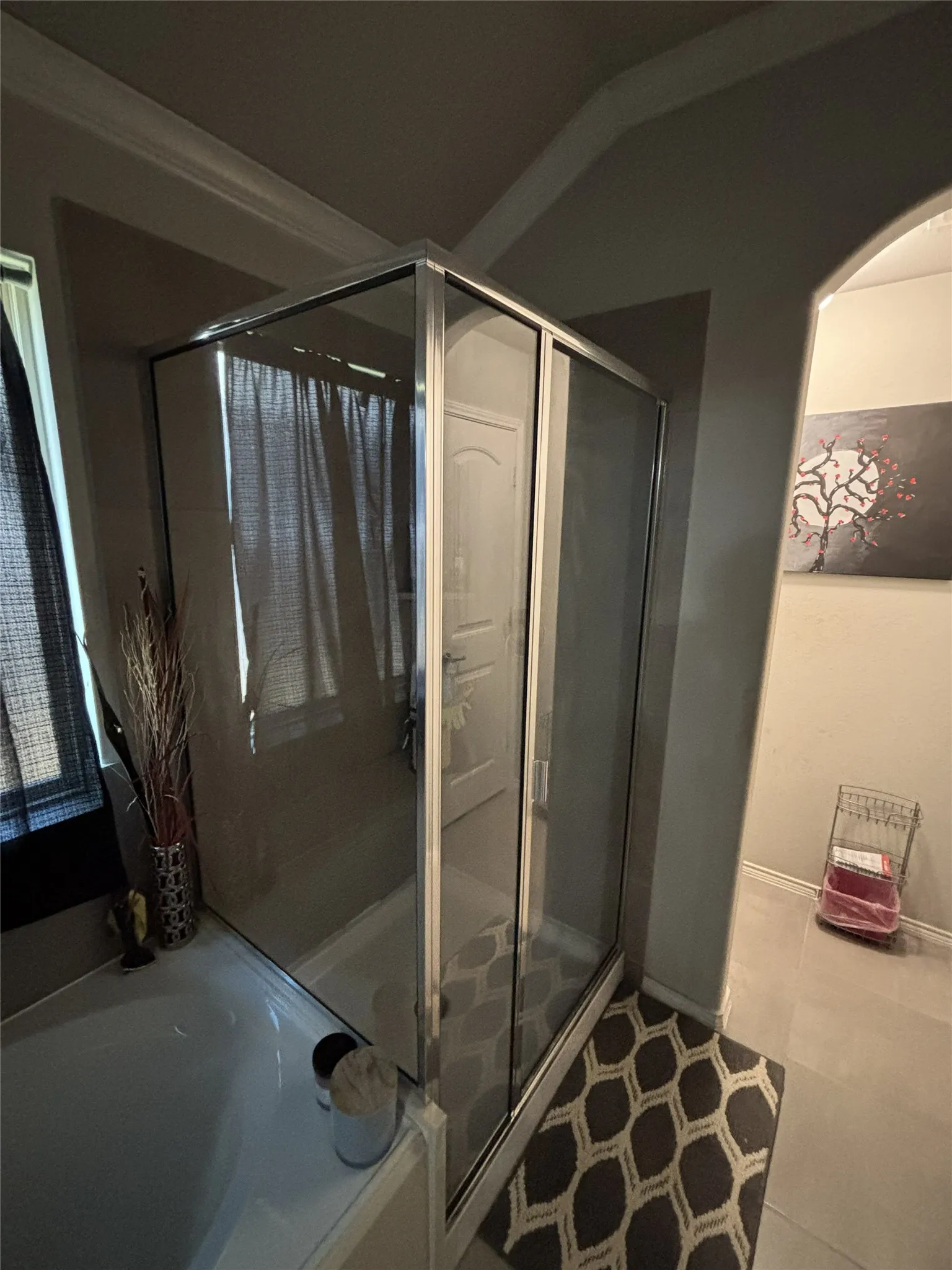 Glass-enclosed shower with sliding doors and a white base, paired with a white built-in tub