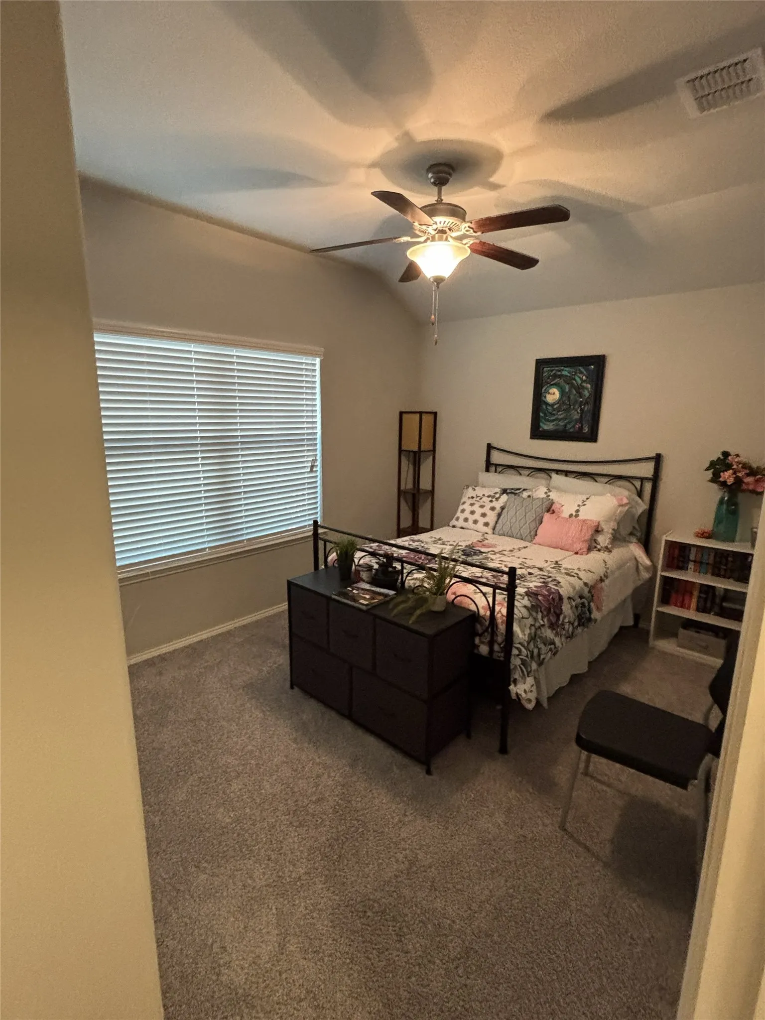 Vaulted ceiling with a ceiling fan, carpeted flooring, and a window with blinds