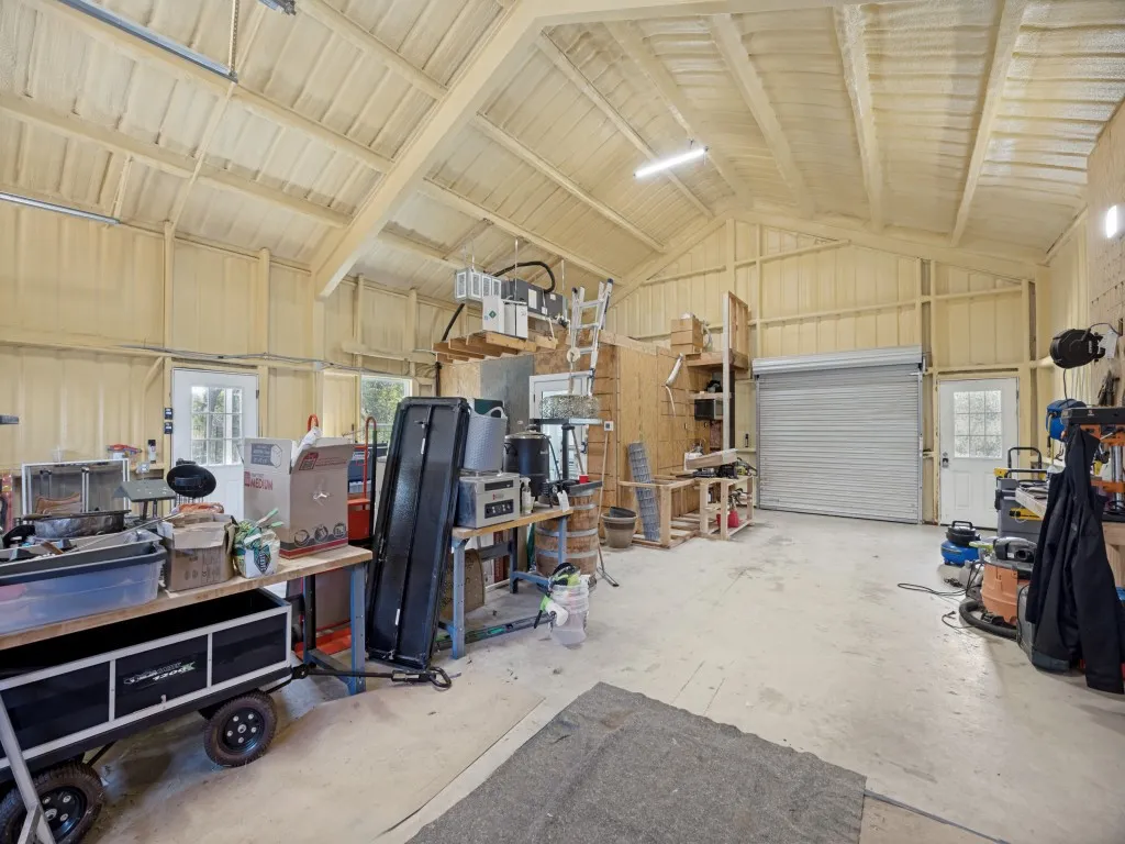 High-ceiling 30'x40' workshop with spray foam insulation, full HVAC system, concrete flooring, and a large roll-up door