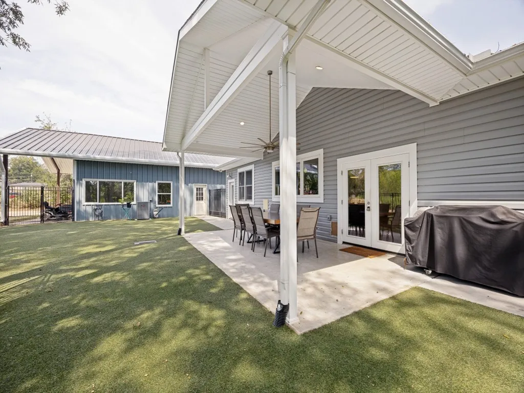 Large covered patio with artificial turf makes for a relaxing space, perfect for entertaining.