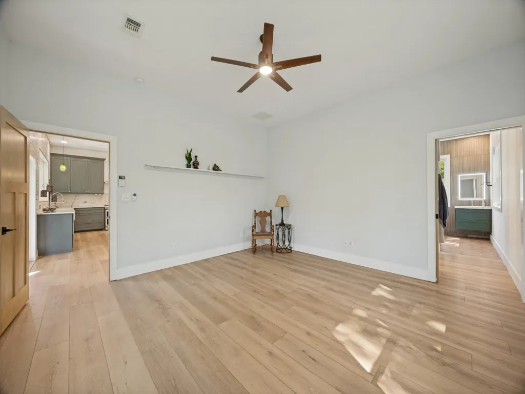 Primary bedroom located on the back of the home with door on left leading to the kitchen and right is the primary bathroom