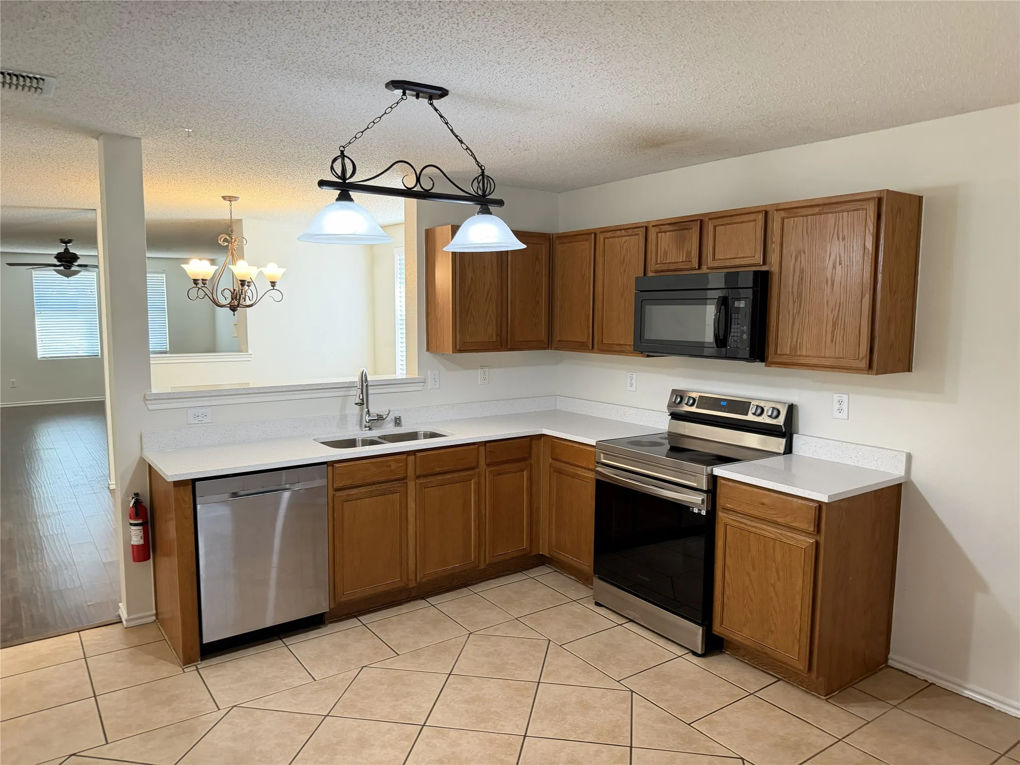 Kitchen featuring wood cabinetry, white countertops, stainless steel appliances, and a tile floor