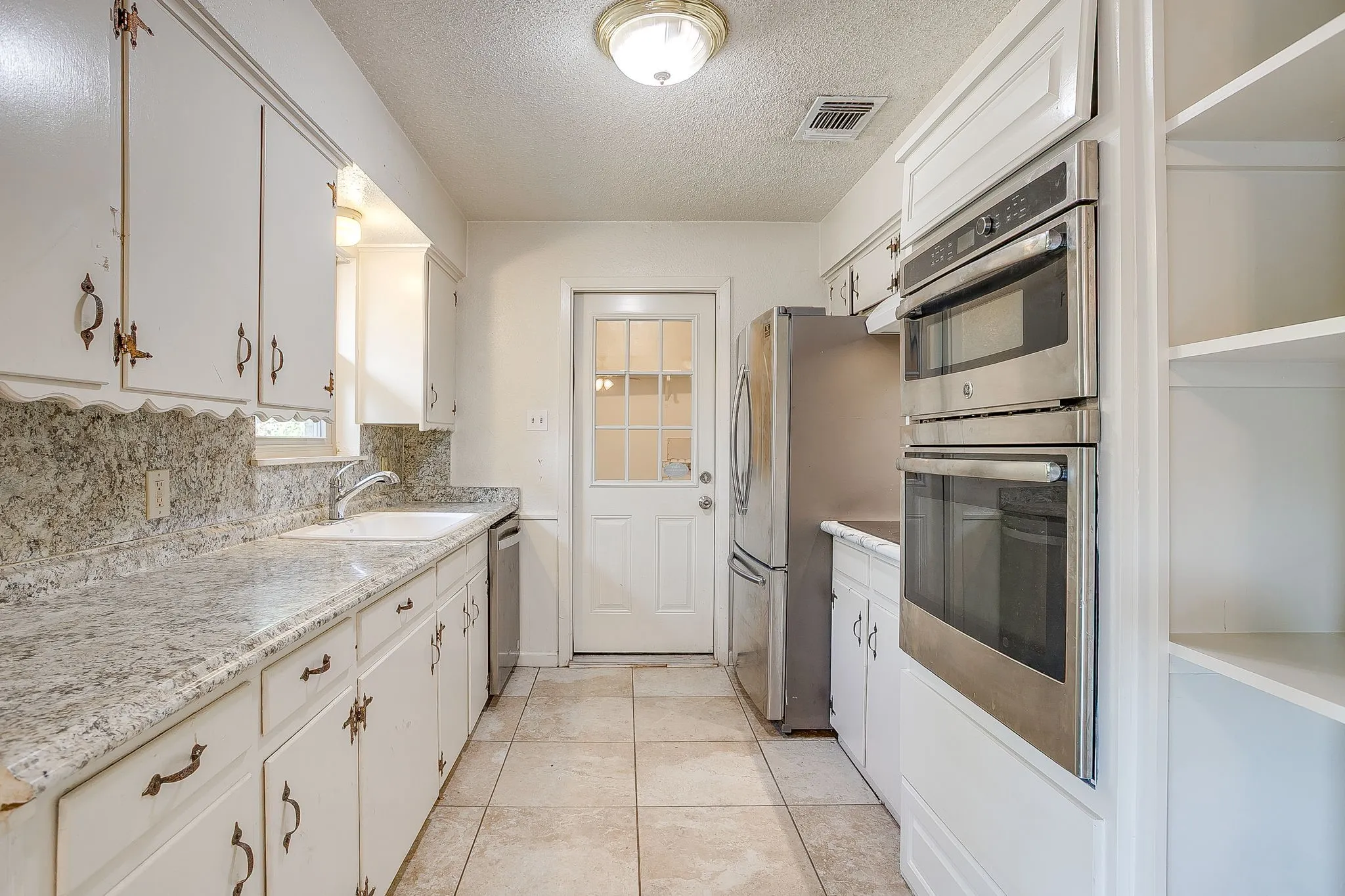Galley kitchen with 'almost new' electric appliances.