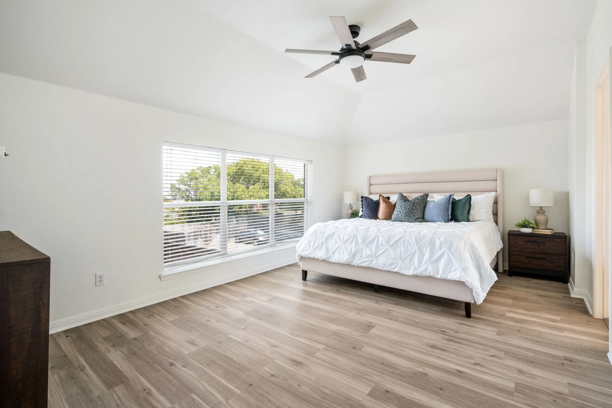 Vaulted ceiling with a contemporary ceiling fan, wood-finish flooring, and expansive windows and beautiful views of Lake Lewisville