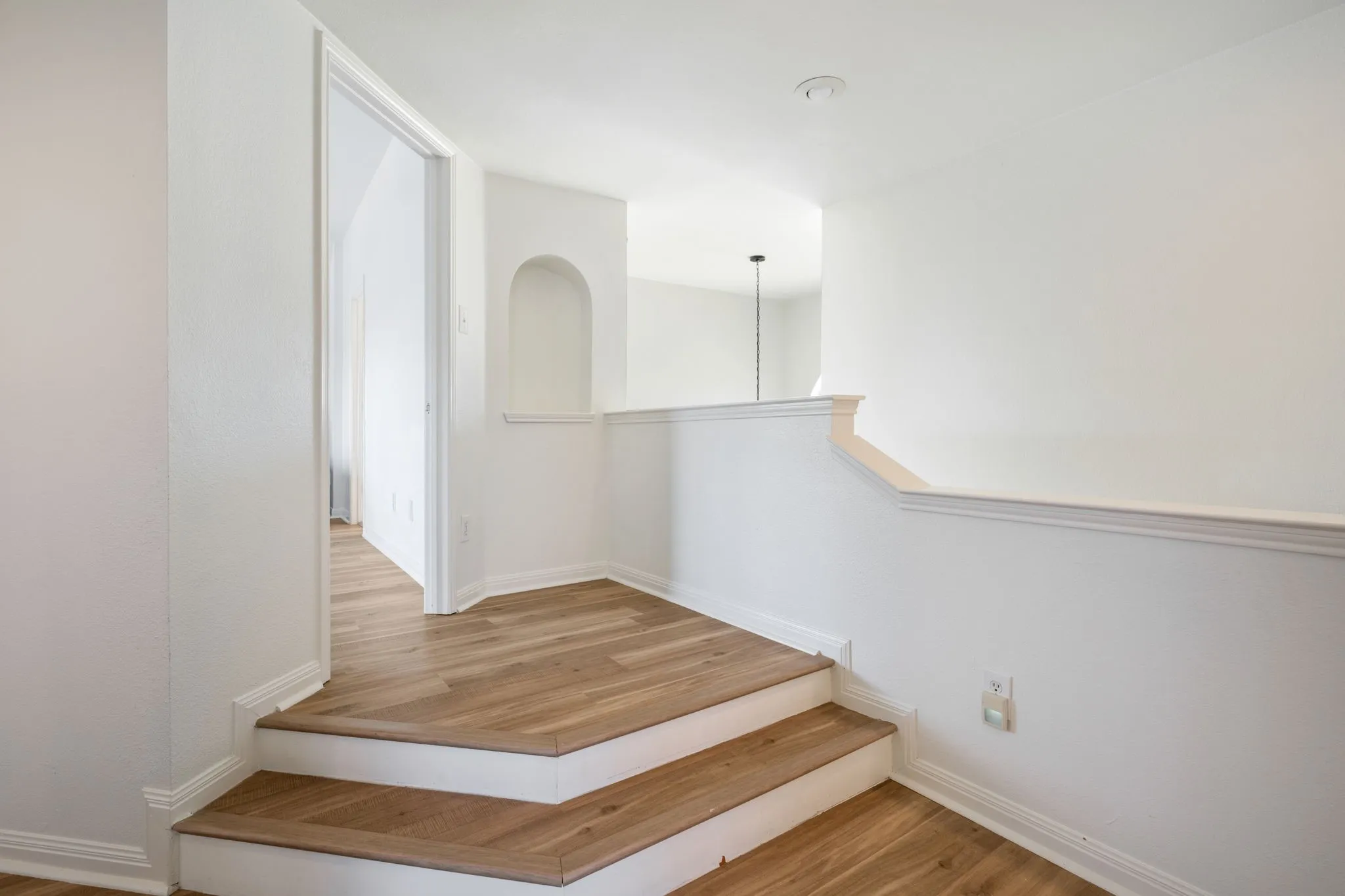 Wood-finish flooring, recessed lighting, and a decorative wall niche