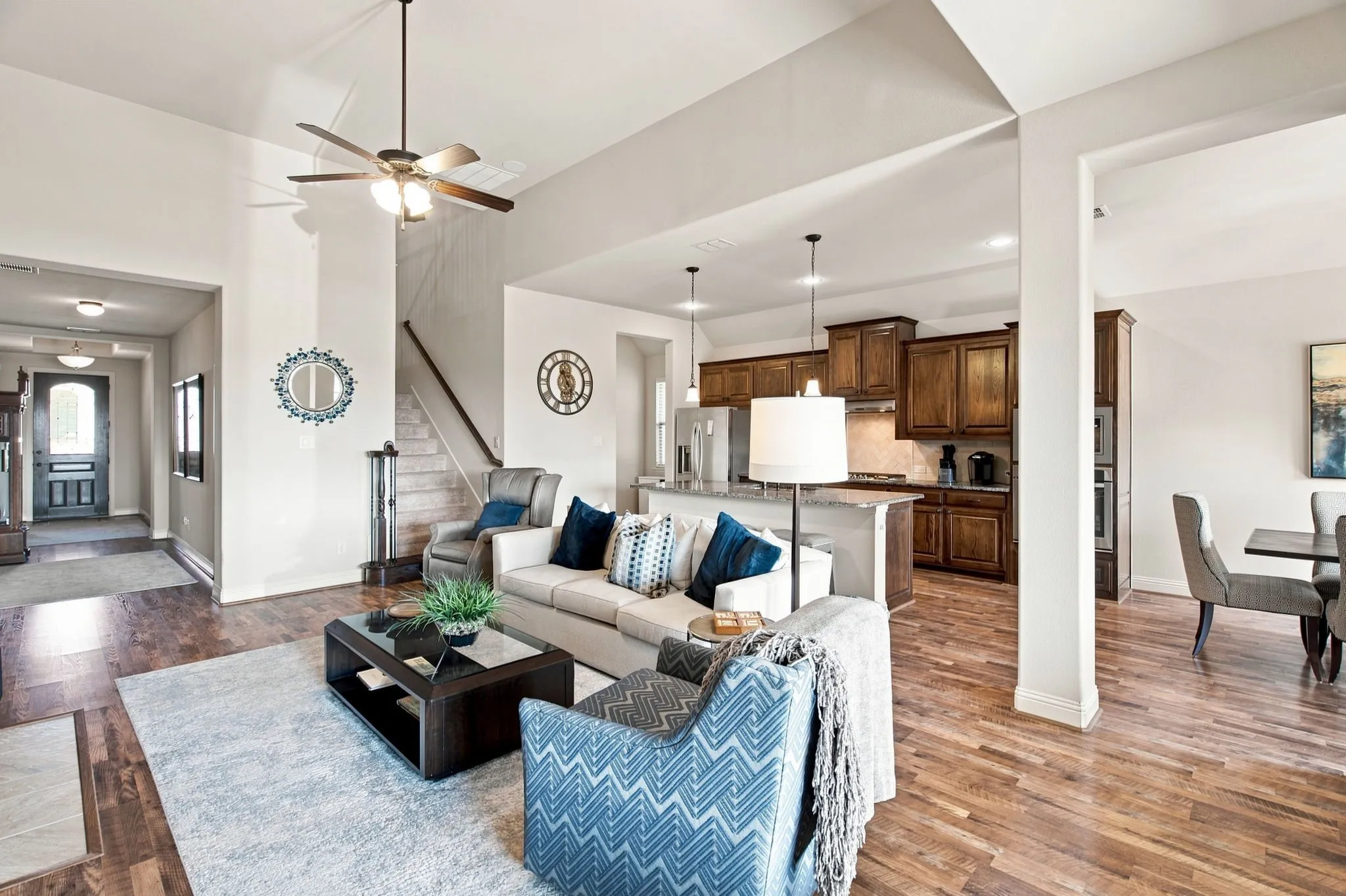 Vaulted ceilings with a ceiling fan, recessed lighting, wood-finish flooring, and a kitchen featuring wood cabinetry and pendant lighting