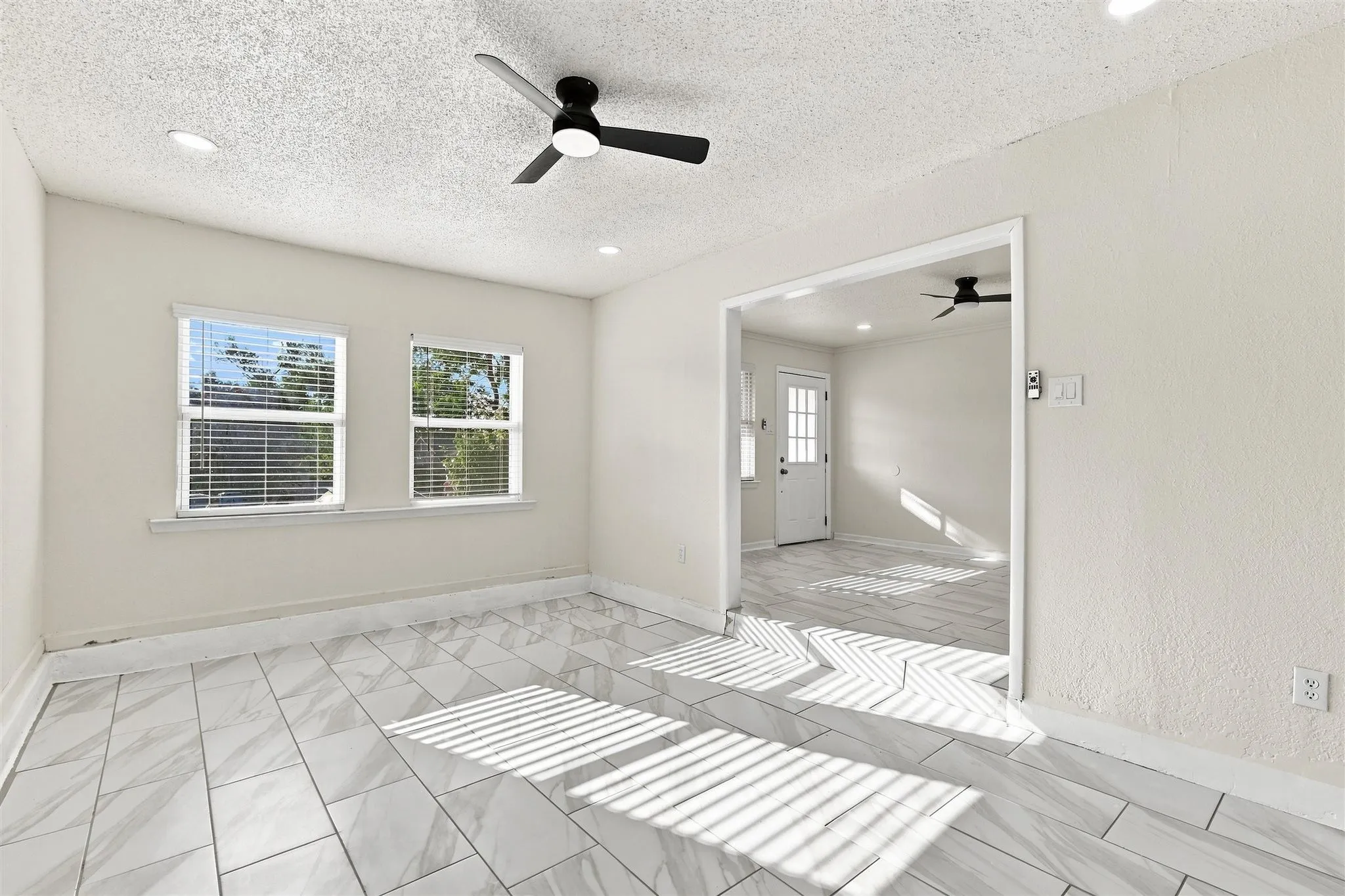White tile flooring, recessed lighting, ceiling fan, and two windows with blinds