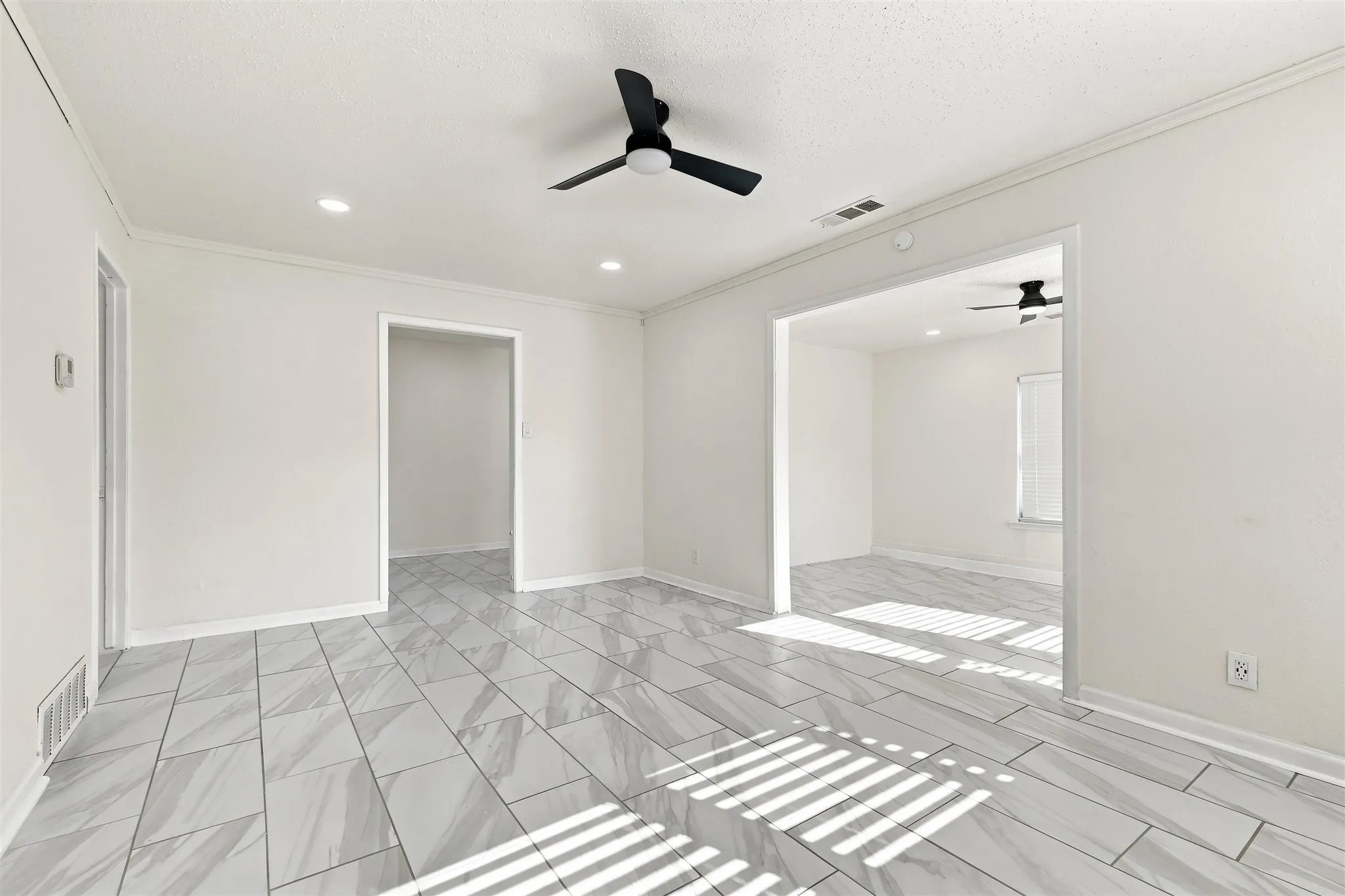 White walls with recessed lighting, gray tile flooring, and a black ceiling fan