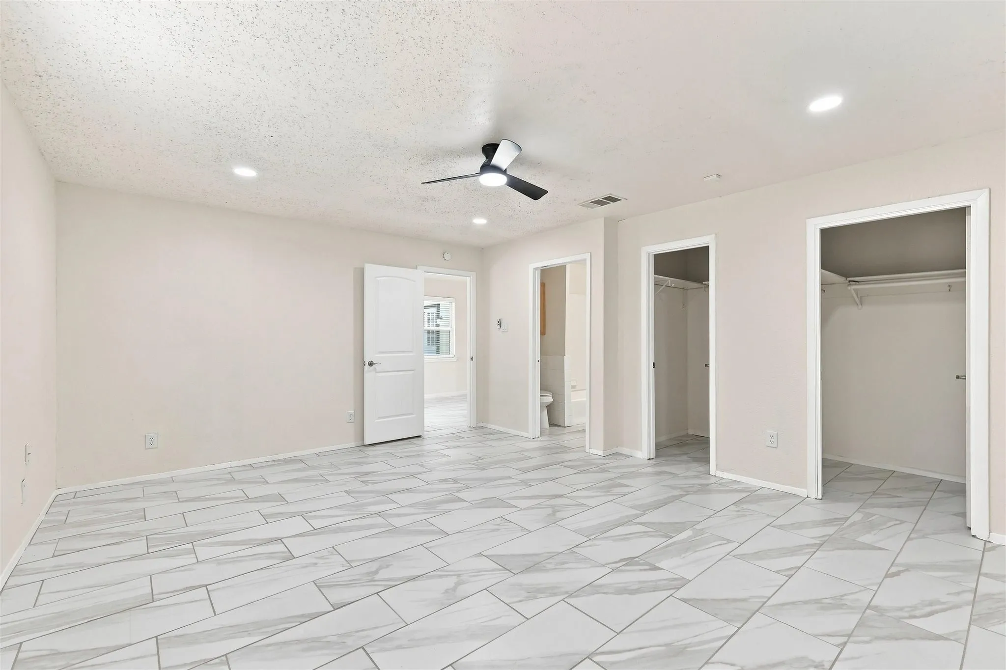 Spacious room featuring tile flooring, ceiling fan, and recessed lighting