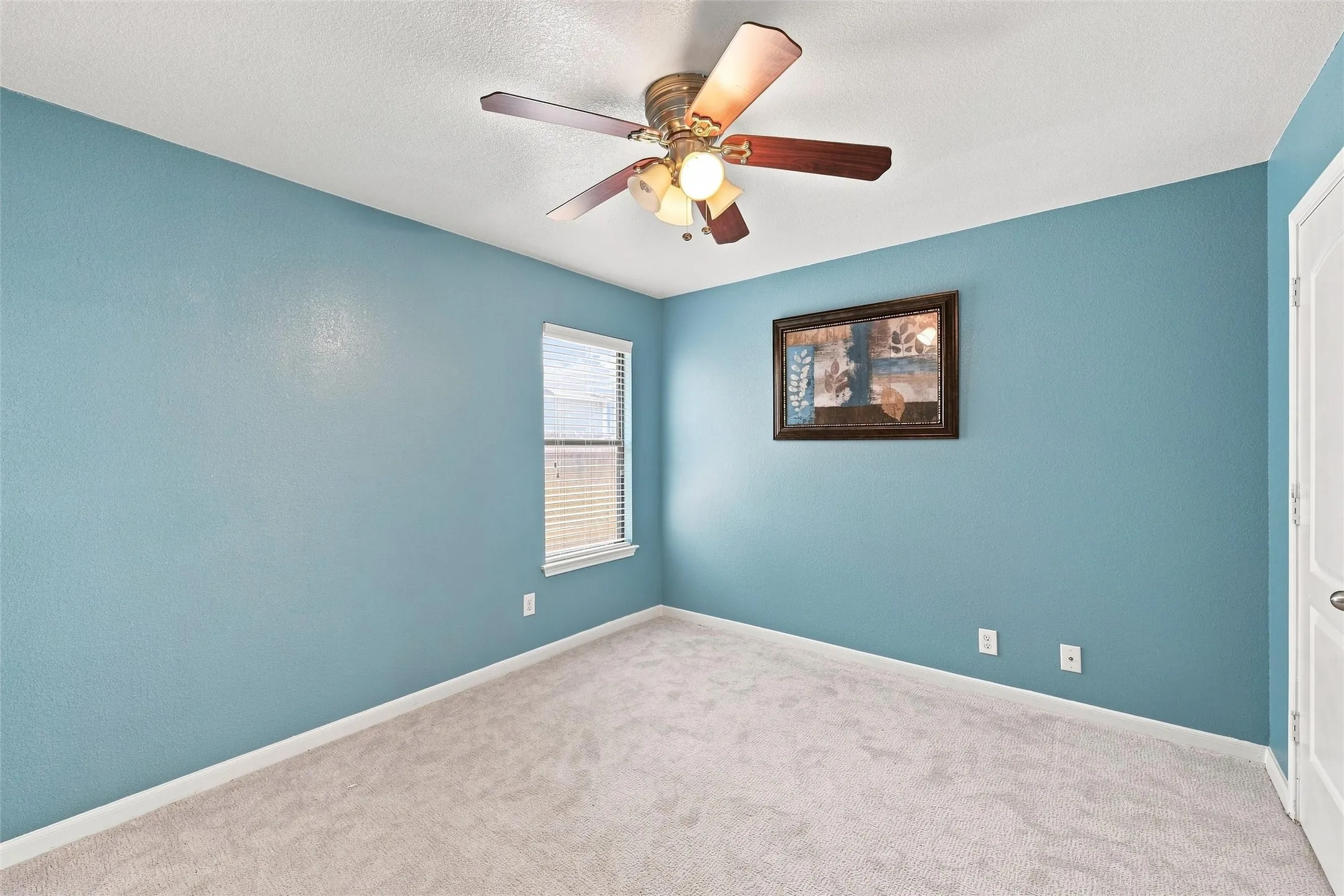 Another comfortable bedroom with soft carpet and natural light.
