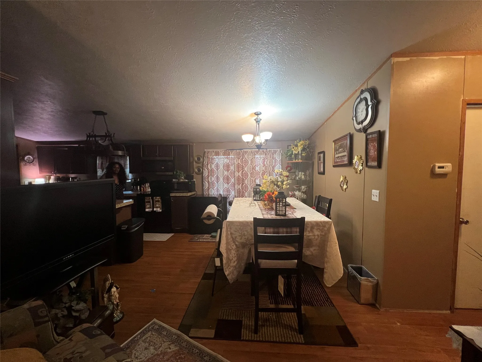 Wood-finish flooring throughout, with a dining area featuring a chandelier