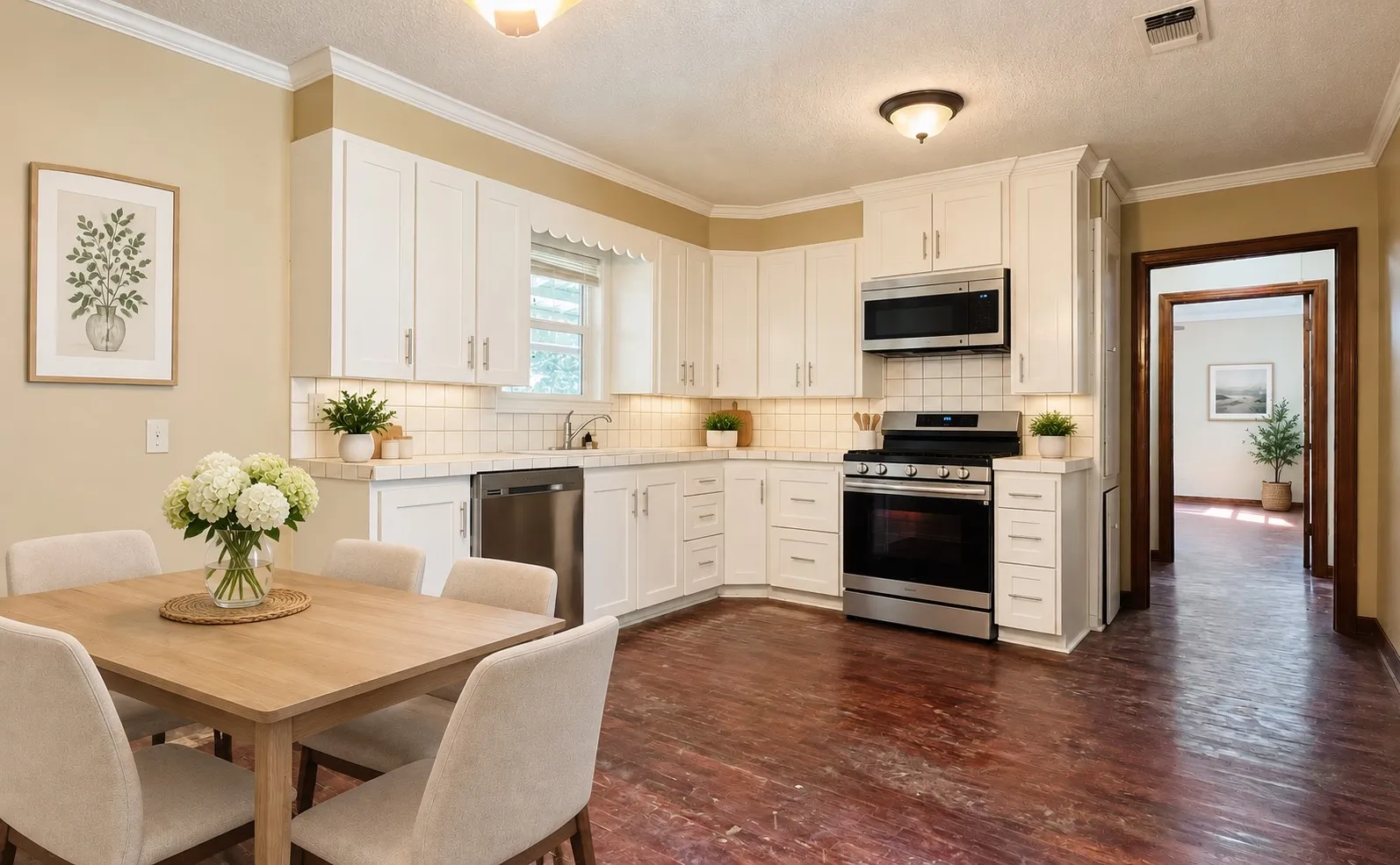Kitchen featuring white cabinetry, stainless steel appliances, a tile backsplash, light countertops, and wood-finish flooring