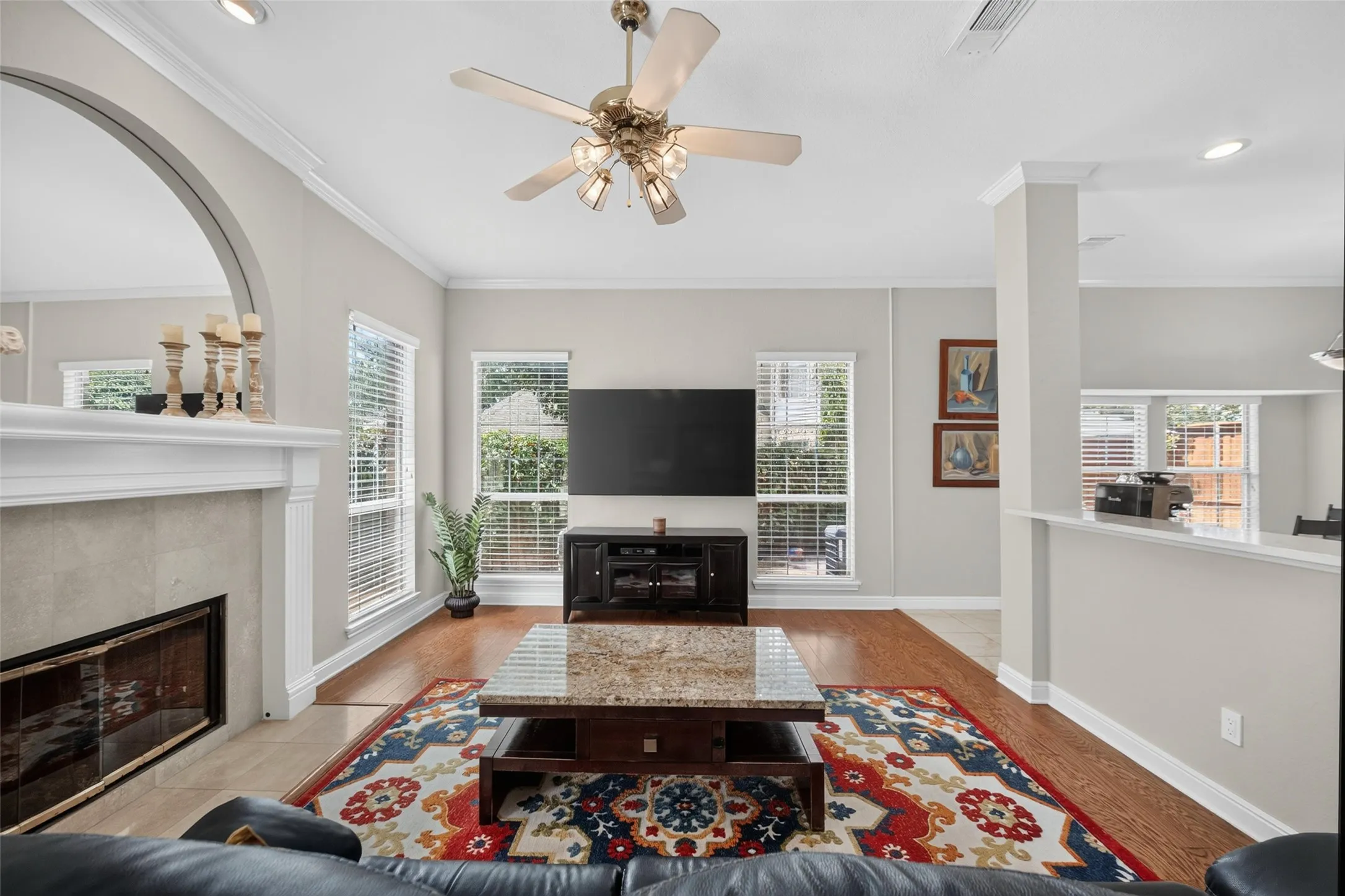 Living area featuring light-toned wall paint, crown molding, and recessed lighting