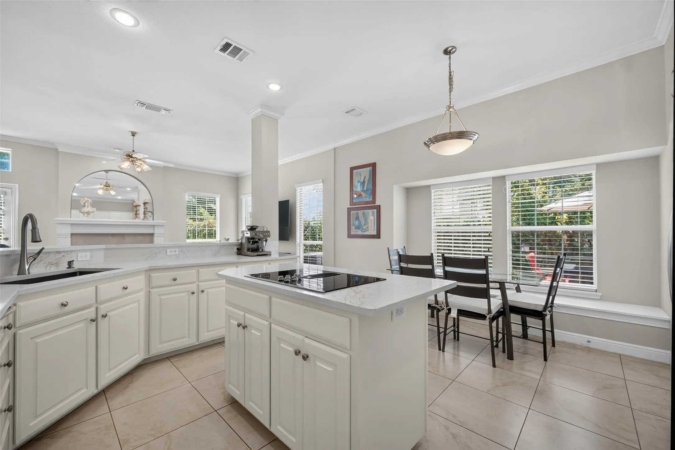 Kitchen featuring white cabinetry, light-toned countertops, a center island with a cooktop, recessed lighting, and tile flooring