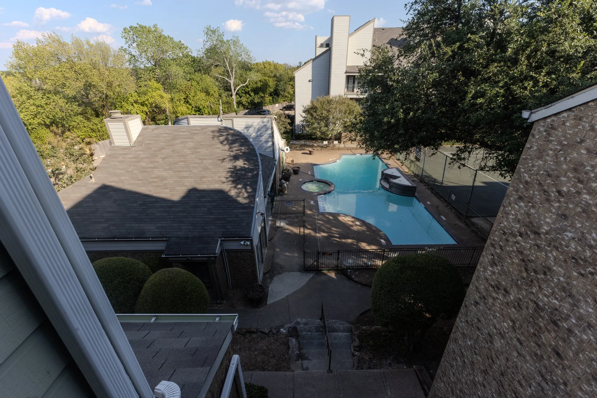 Outdoor swimming pool with integrated spa and surrounding paved patio